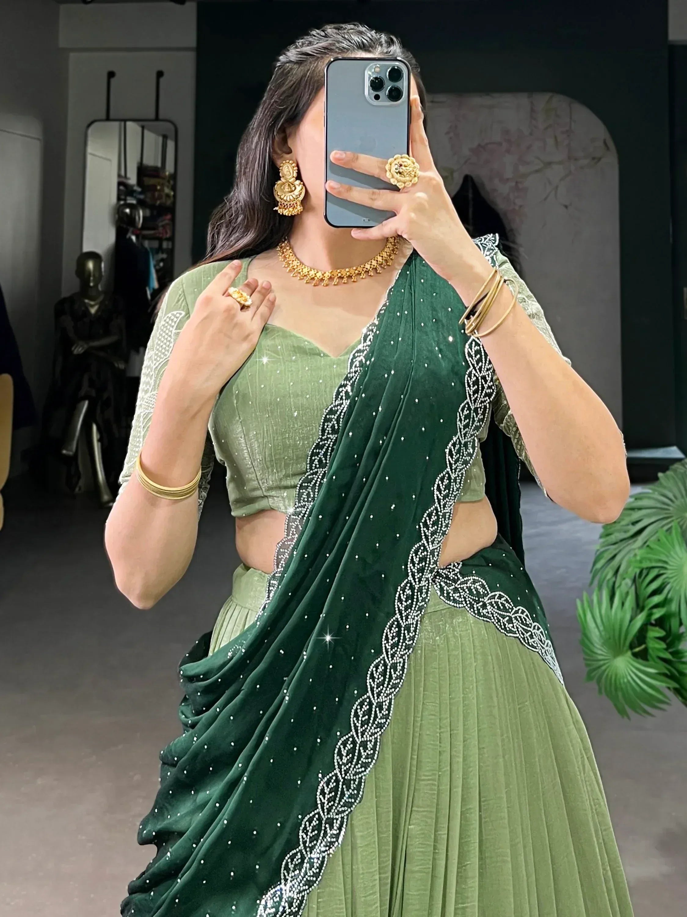 Green velvet saree with silver embroidery, paired with matching blouse and gold jewelry for ethnic wear