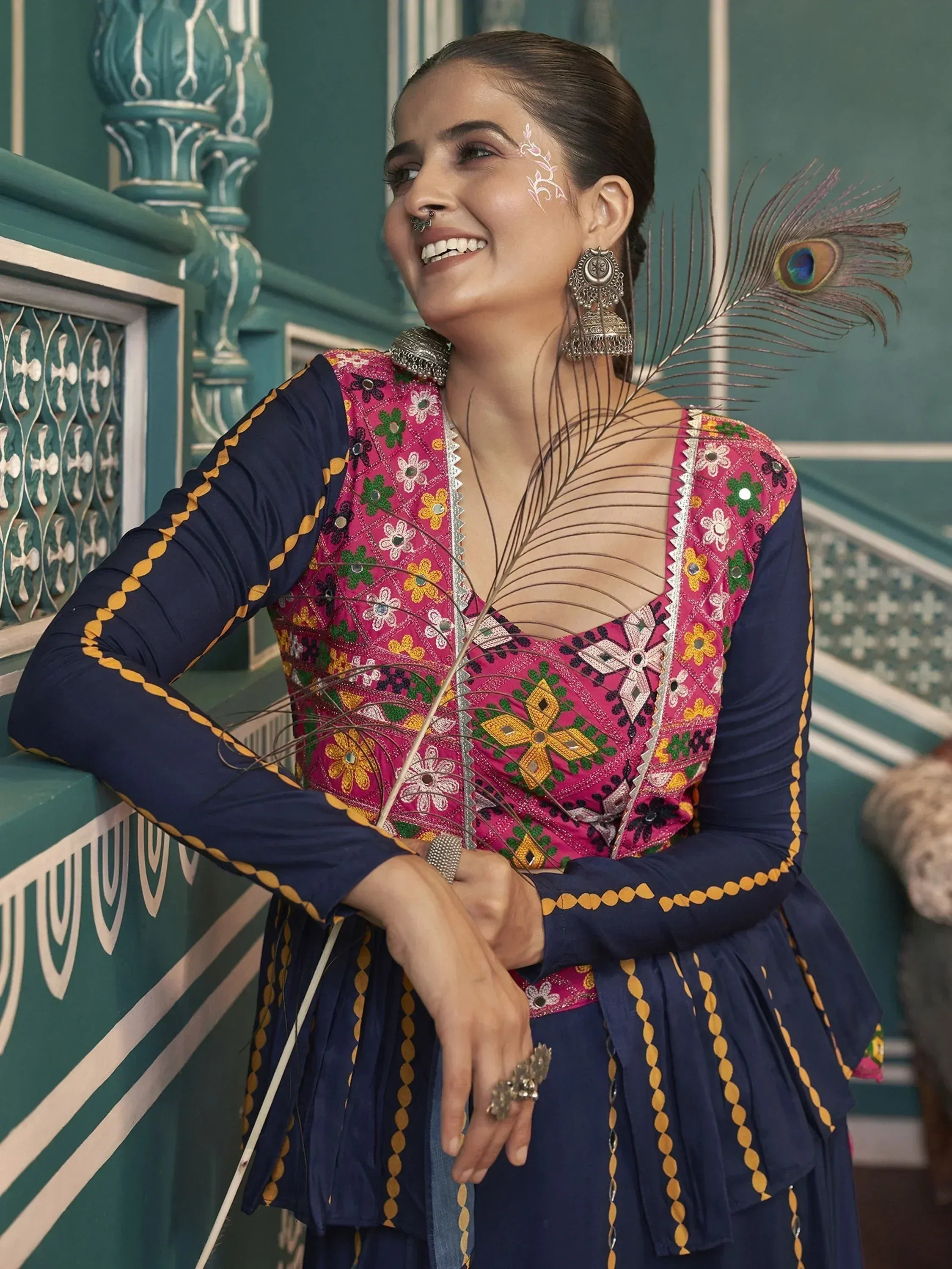Woman in vibrant embroidered ethnic gown with peacock feather, traditional Indian attire