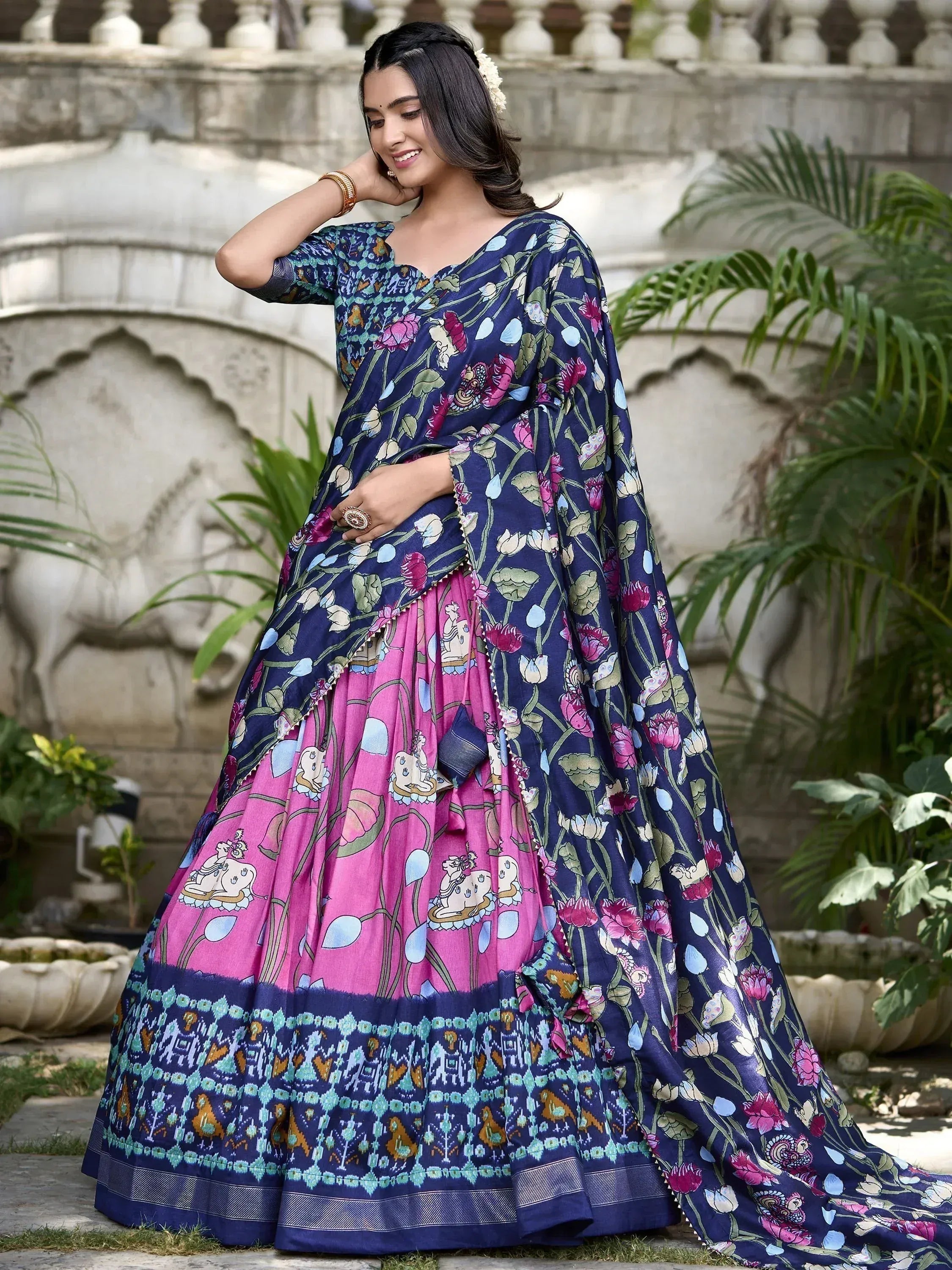 Woman in navy floral lehenga choli with pink skirt, traditional Indian ethnic wear for festive occasions