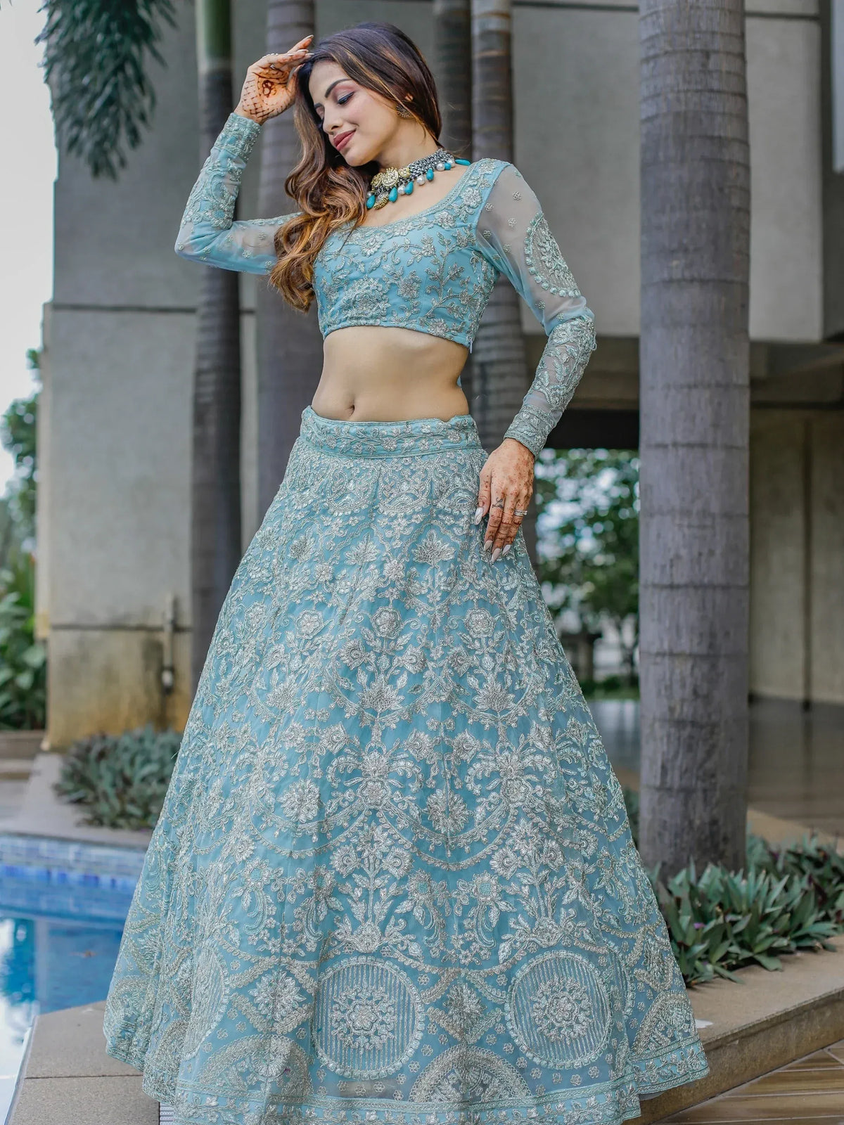 Elegant light blue embroidered lehenga choli with sheer sleeves, perfect for Indian ethnic wear occasions.