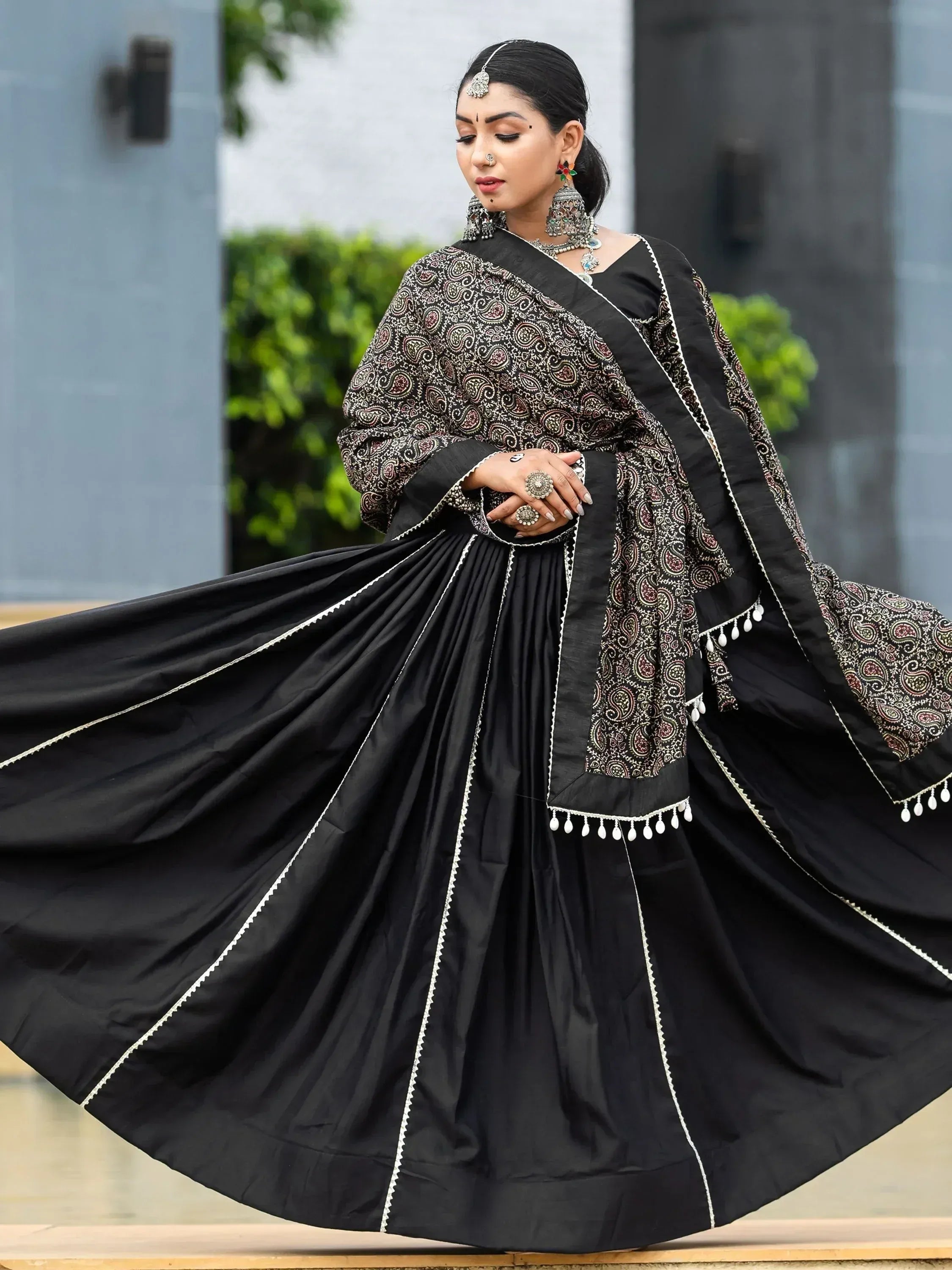 Black ethnic lehenga choli with paisley print and white trim, perfect for Indian weddings and festive occasions.
