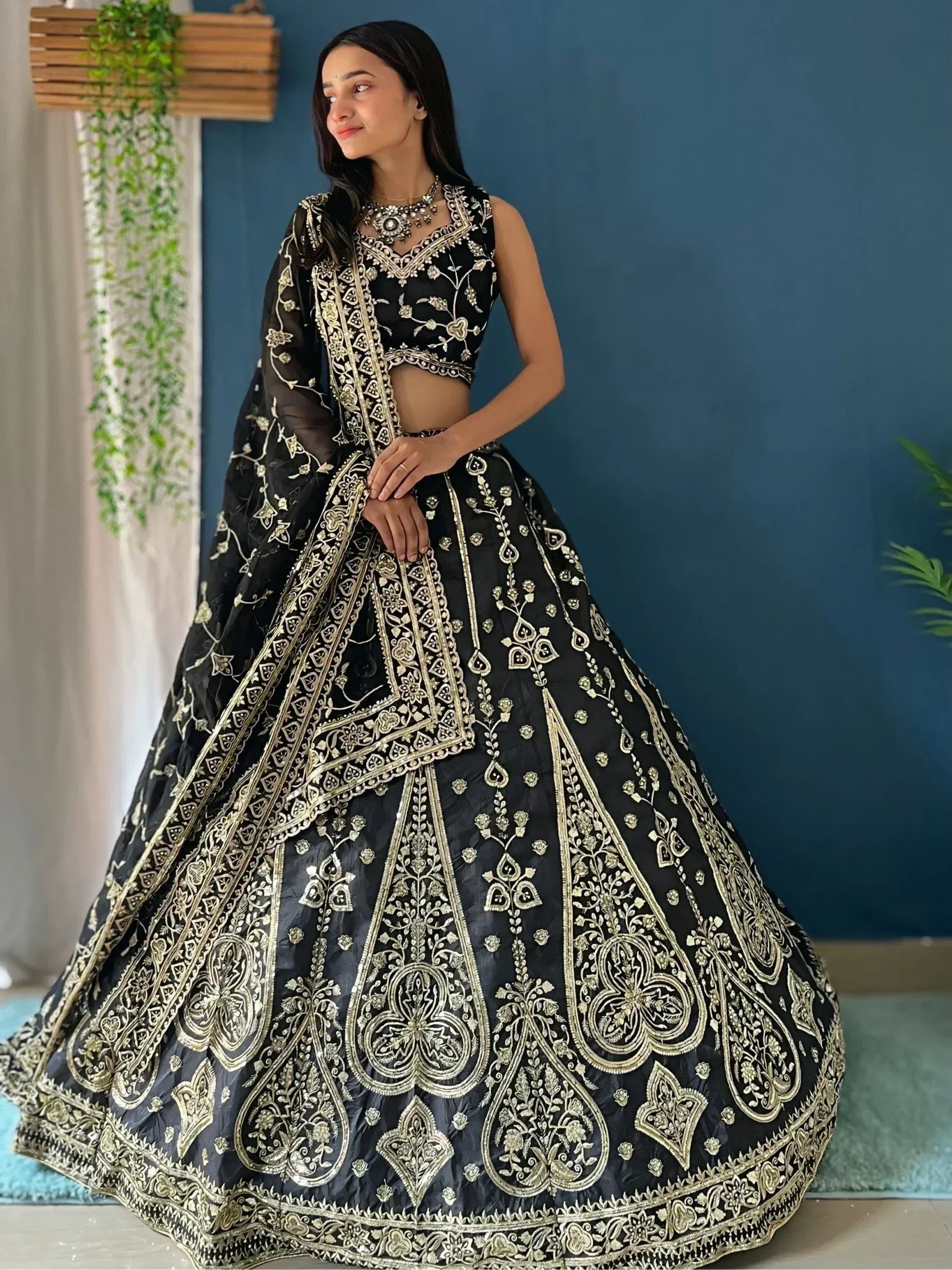 Black and gold embroidered lehenga choli with intricate floral and paisley designs, perfect for Indian ethnic wear.