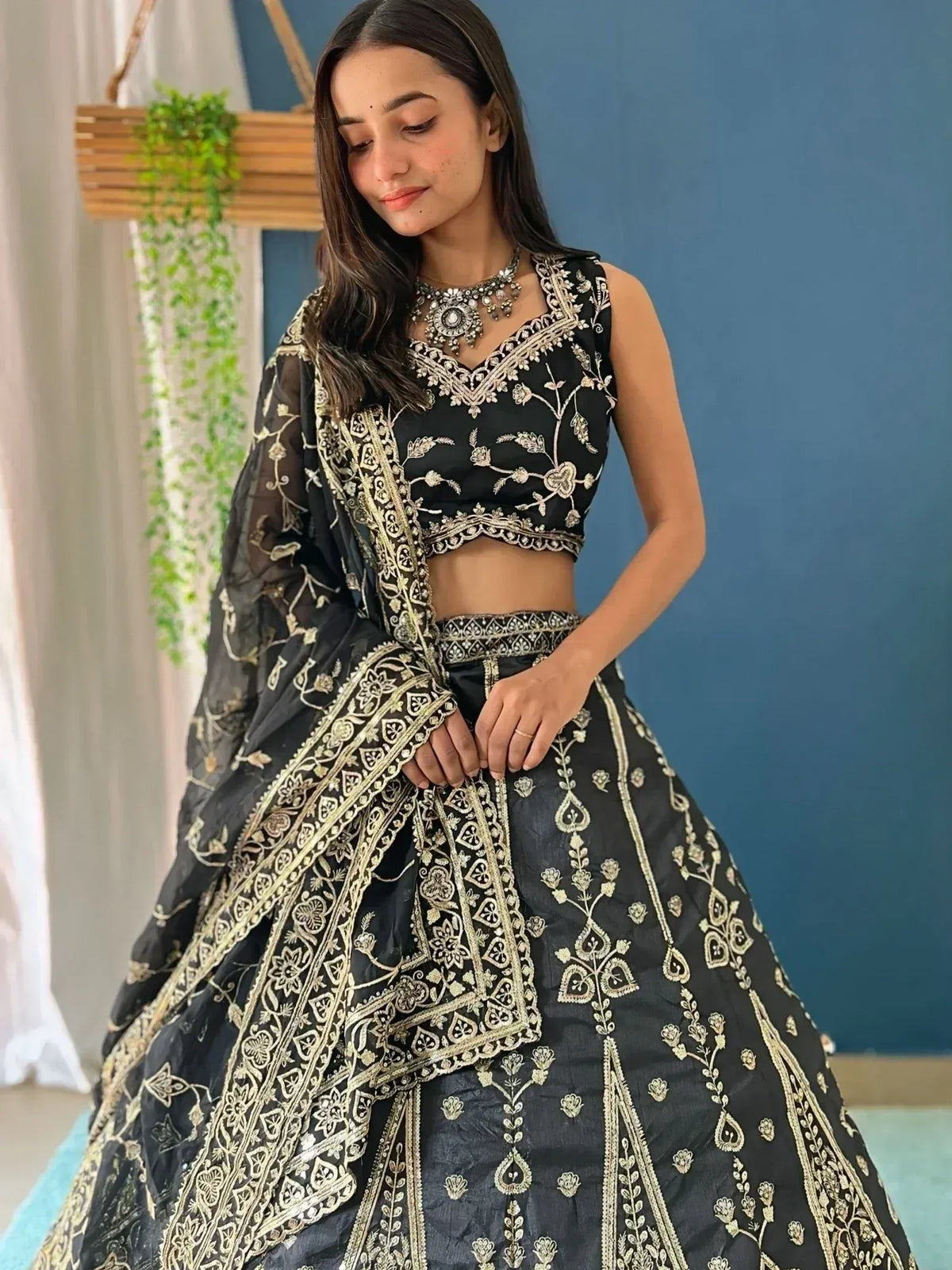 Black and gold embroidered lehenga choli with floral motifs, perfect for Indian ethnic occasions