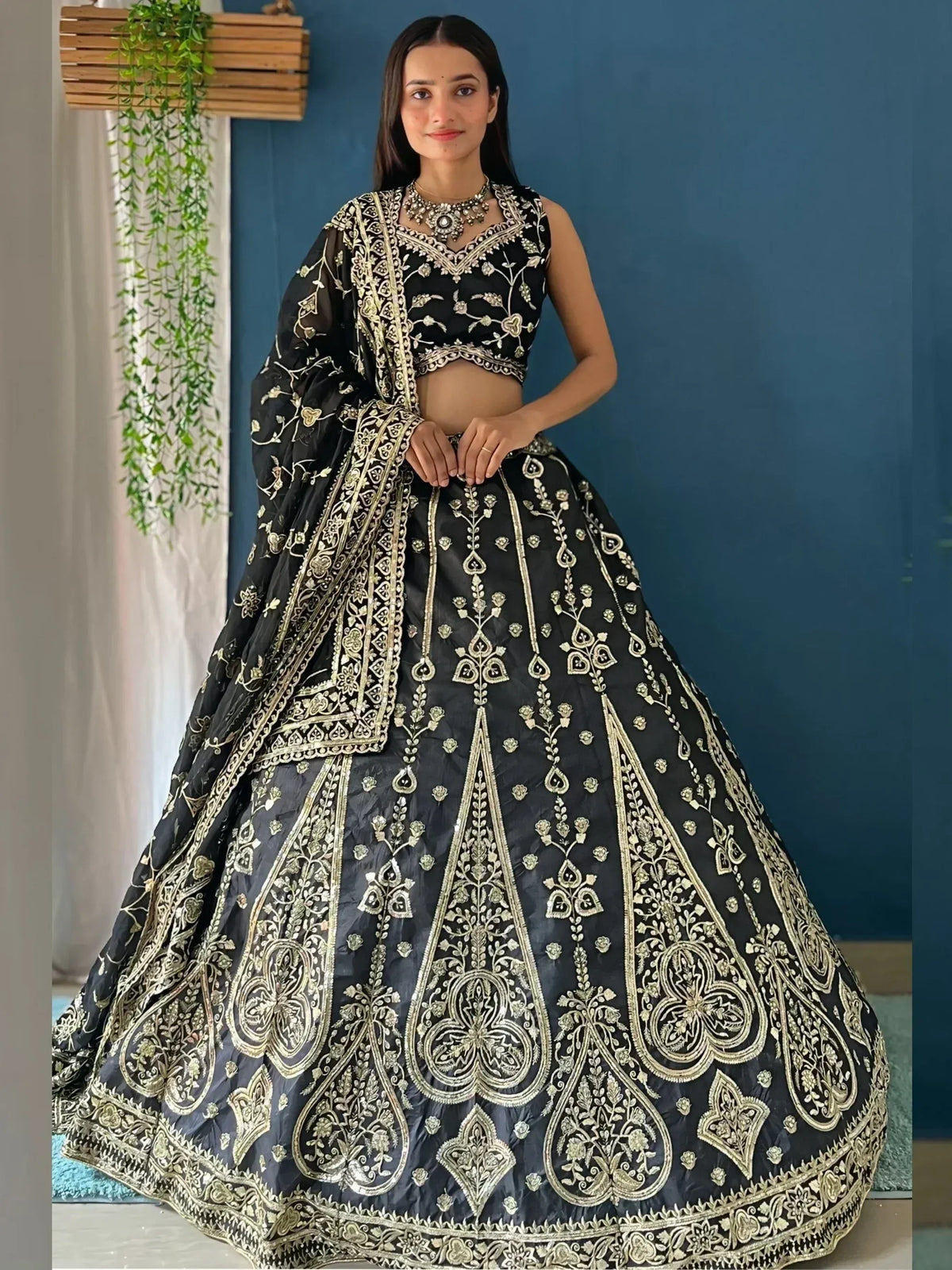 Black and gold embroidered lehenga choli with floral zari work, perfect for weddings and festive occasions.