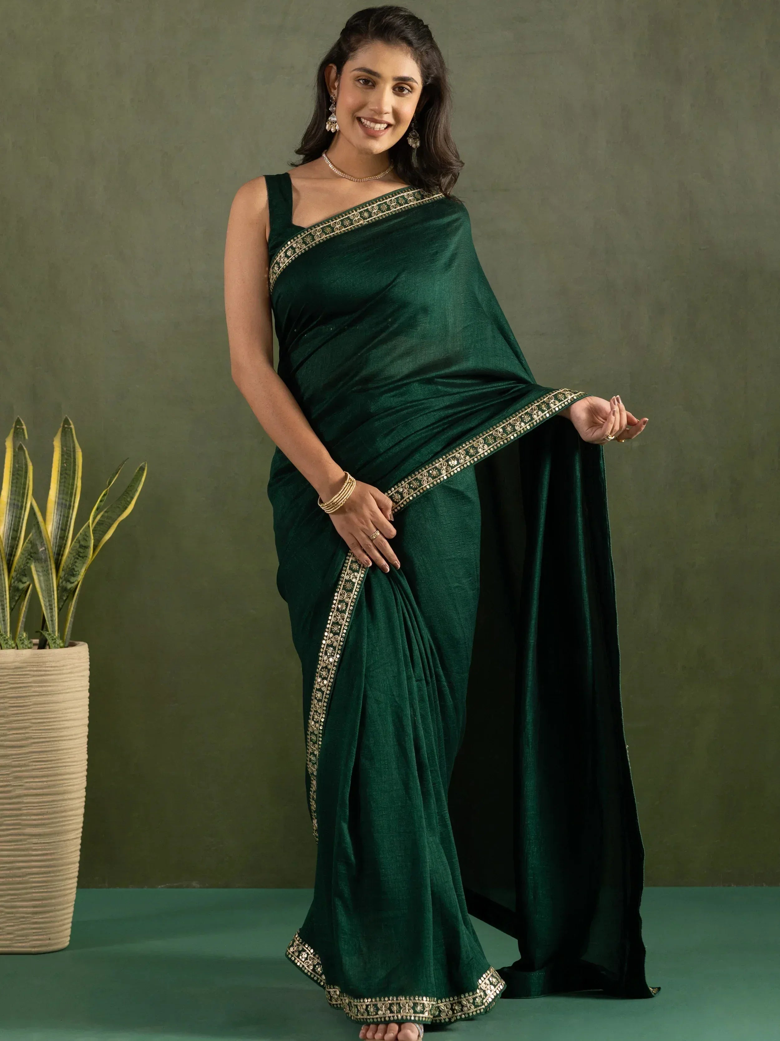 Emerald green ethnic saree with gold embroidery, perfect for Indian occasions and festive wear.