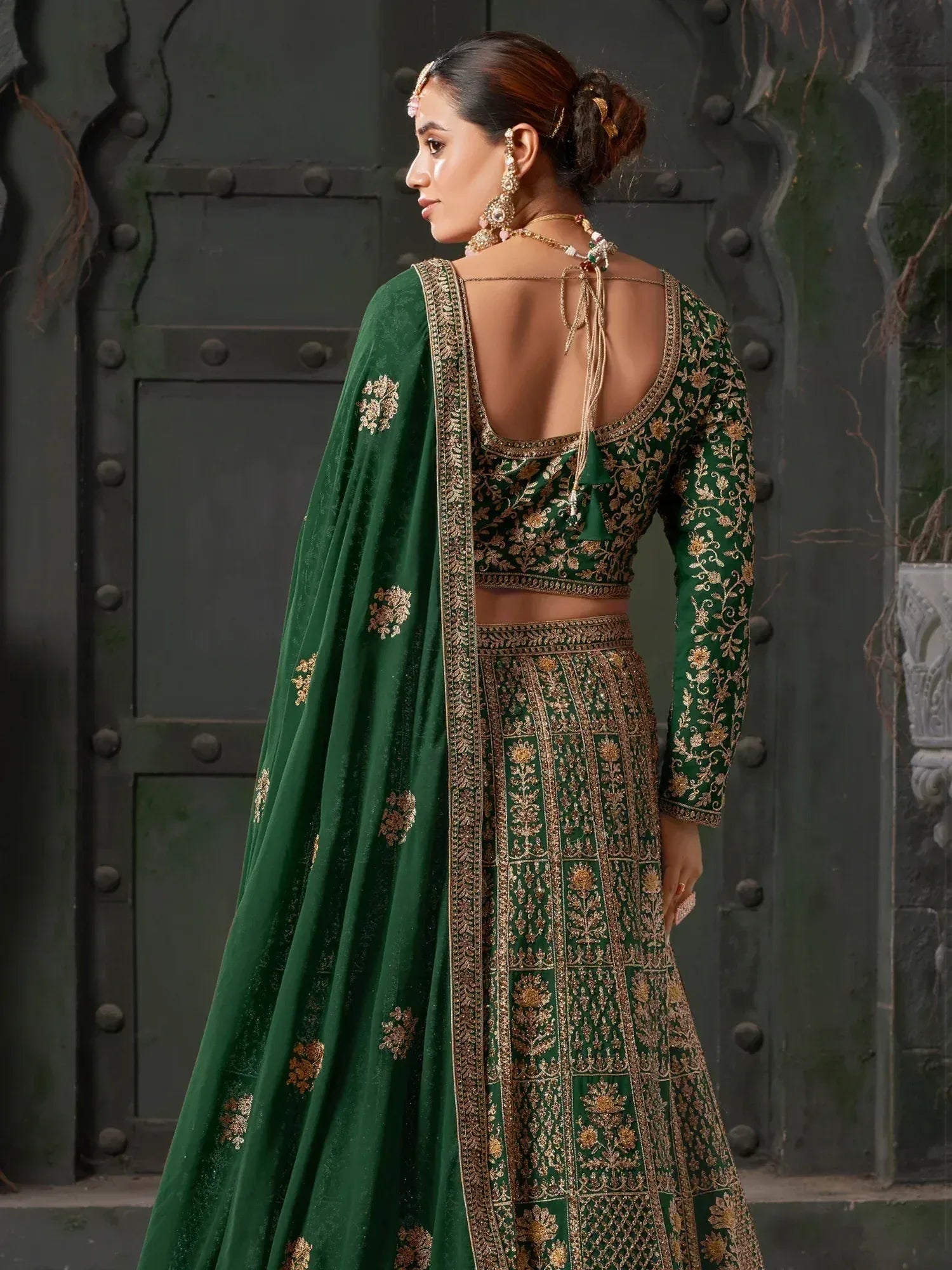 Emerald green designer lehenga choli with gold embroidery, perfect for Indian weddings and festive occasions.