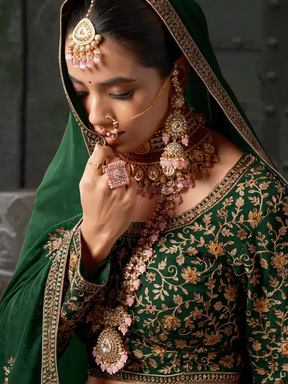 Emerald green embroidered lehenga choli with pink gold jewelry, traditional Indian bridal wear