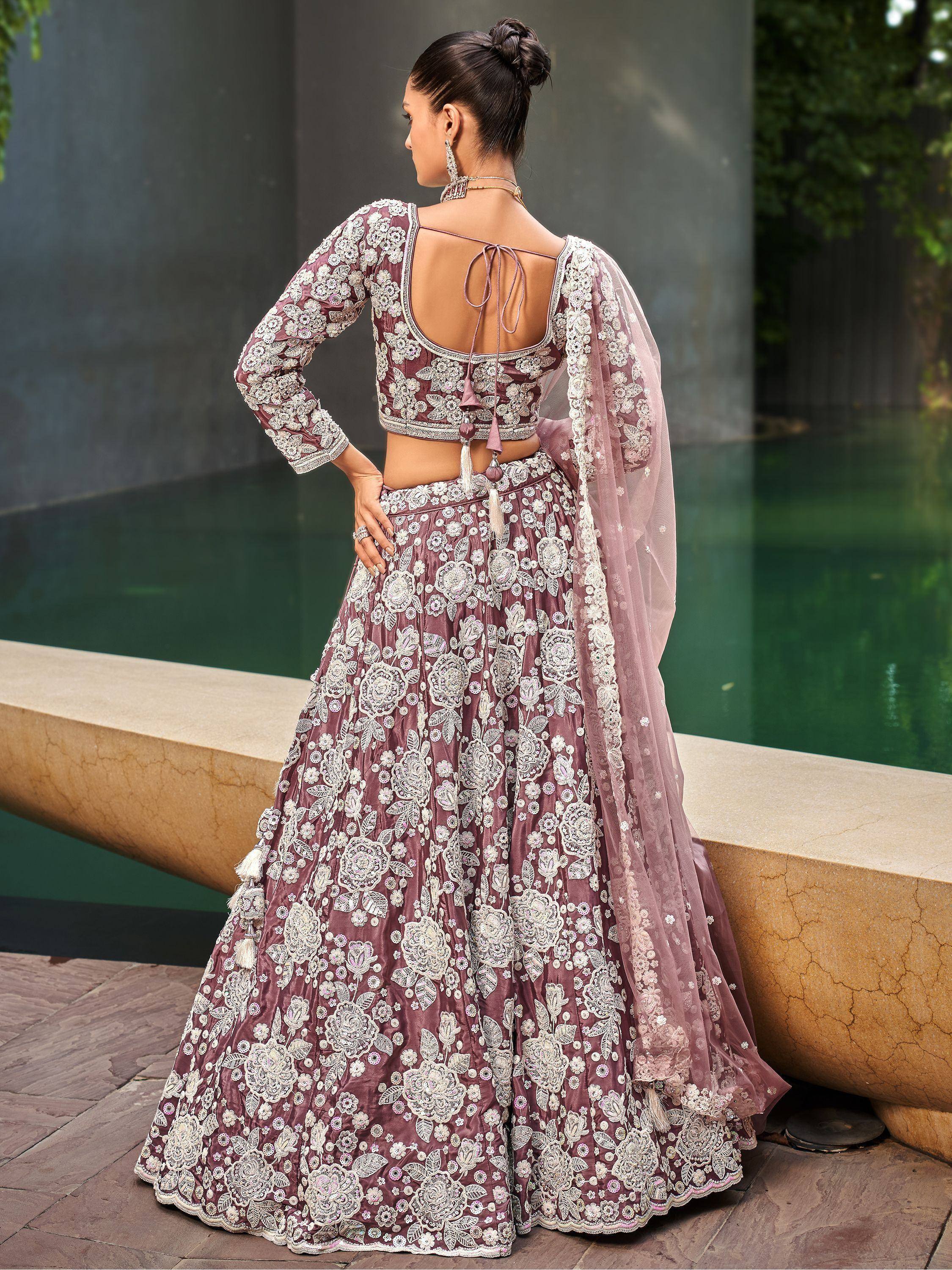 Elegant mauve lehenga choli with floral embroidery, backless blouse, and sheer dupatta for Indian weddings.