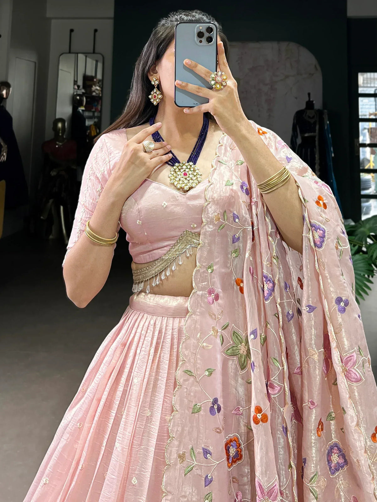Pink floral embroidered lehenga choli with gold detailing and matching dupatta, styled with traditional jewelry.