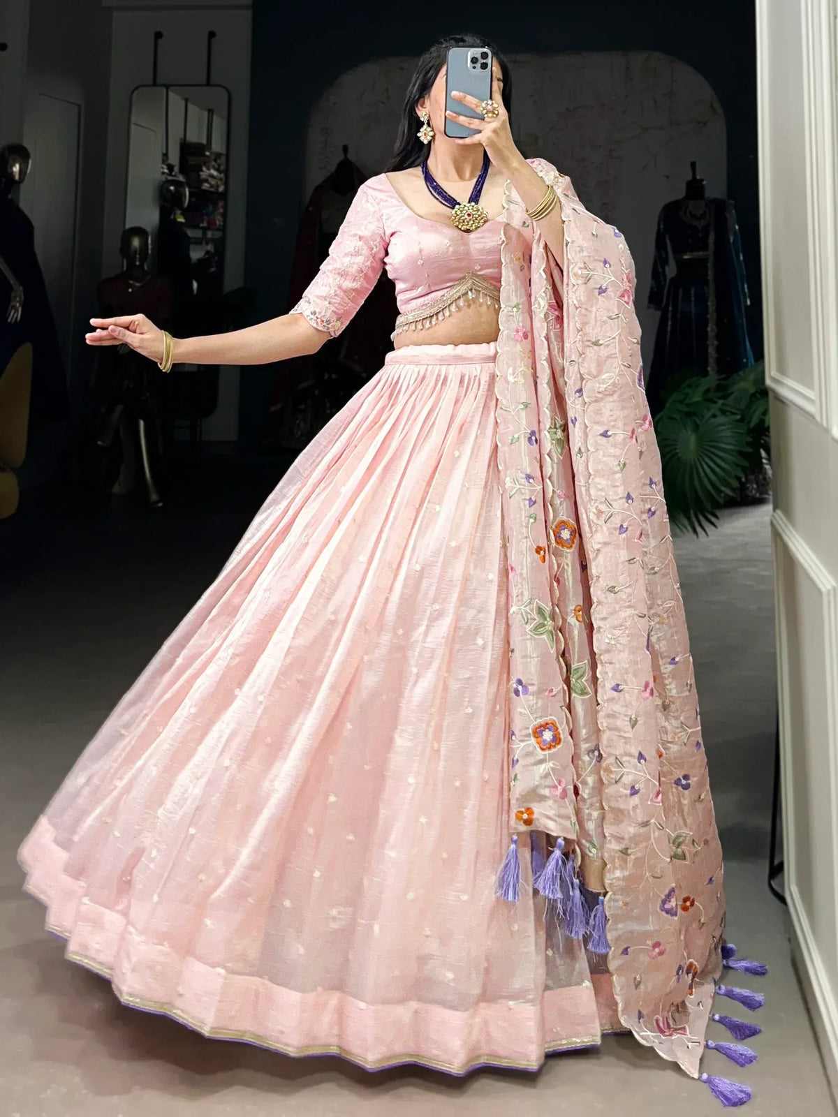 Pink designer lehenga choli with floral embroidery and tassels, perfect for Indian ethnic occasions