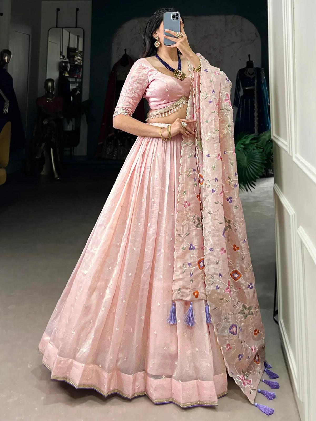Pink designer lehenga choli with floral embroidery and tassels, perfect for Indian ethnic wear occasions.