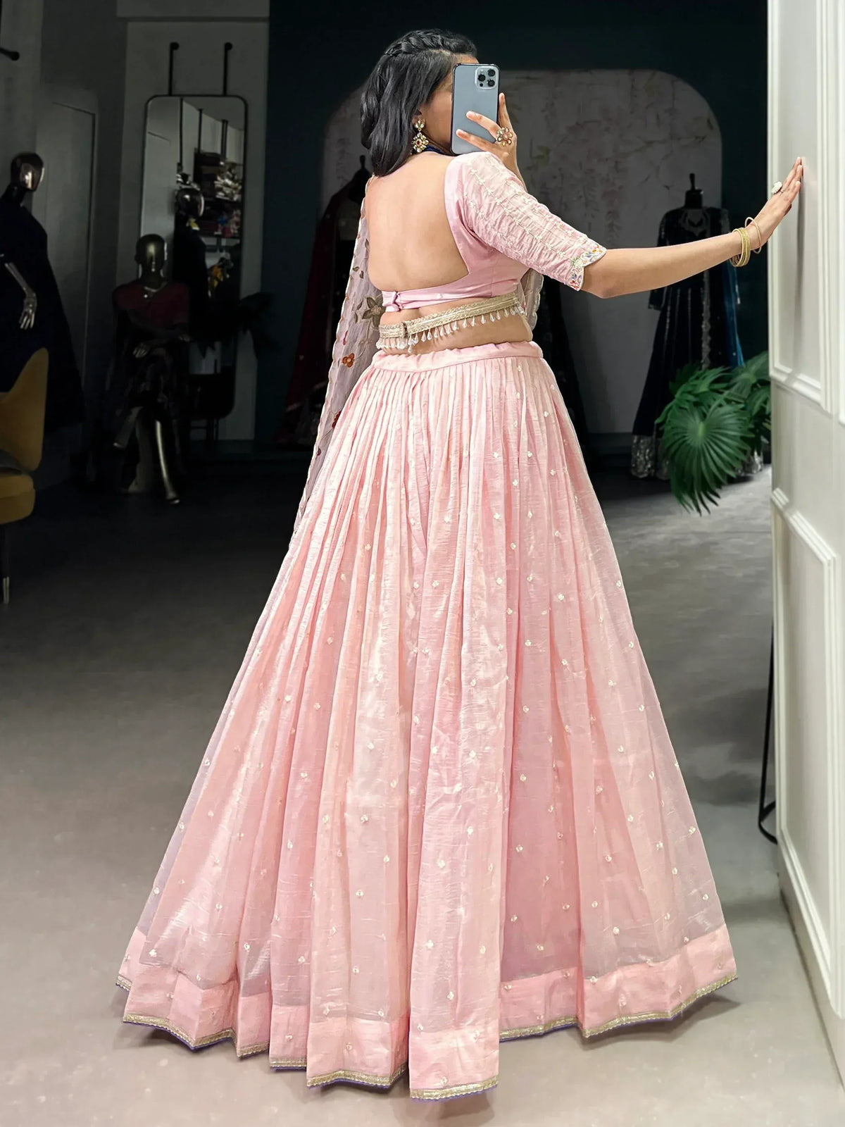 Pink designer lehenga choli with backless blouse, gold embellishments, and sheer dupatta for Indian ethnic wear