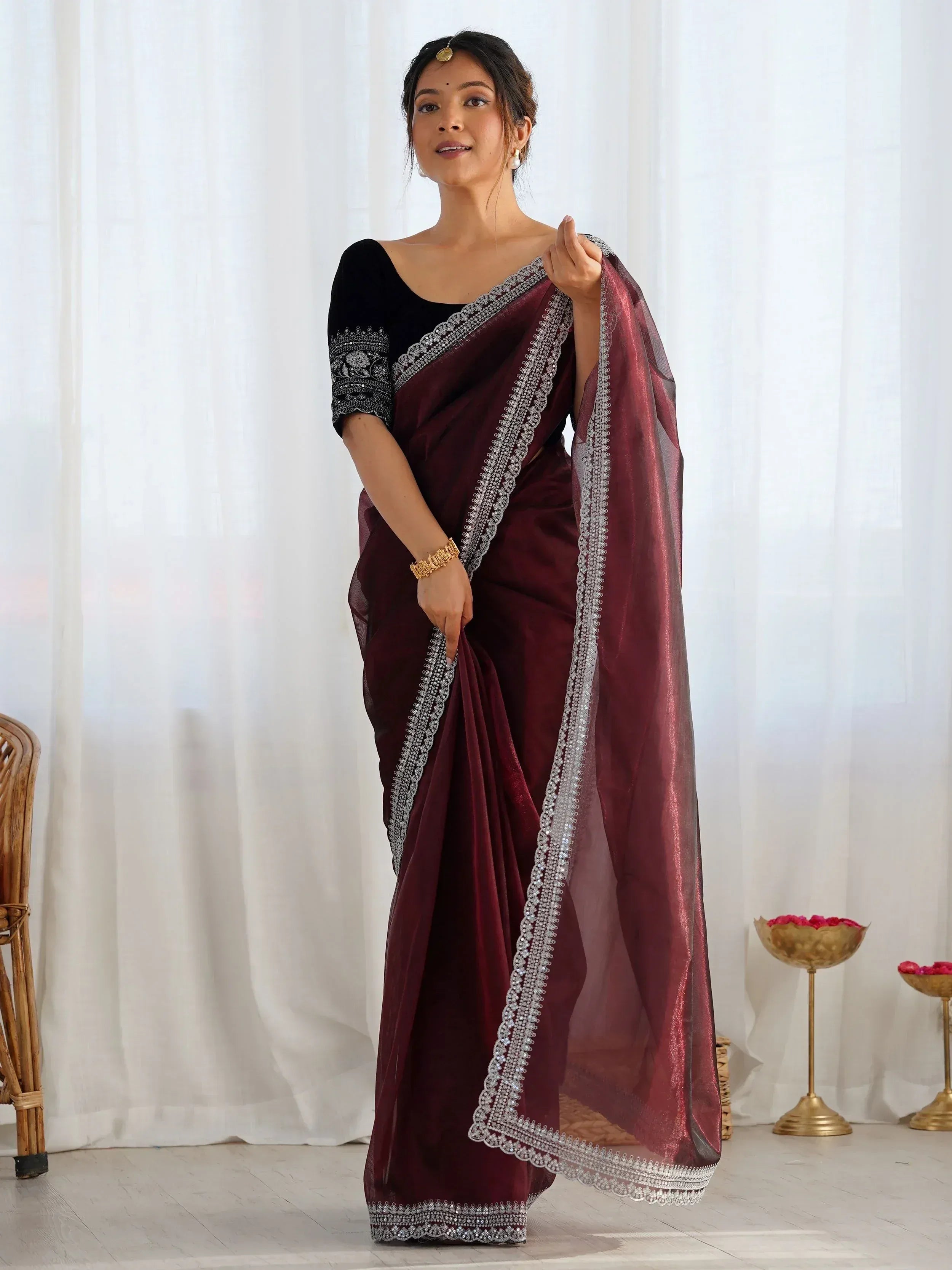 Woman in maroon velvet saree with silver embroidery, black blouse, perfect for Indian ethnic occasions.
