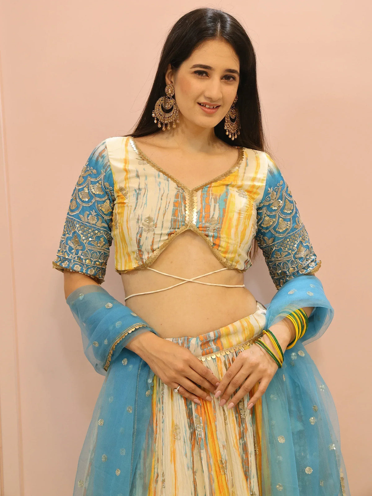 Blue and yellow ethnic lehenga choli with gold embroidery and sheer dupatta, perfect for Indian festive occasions