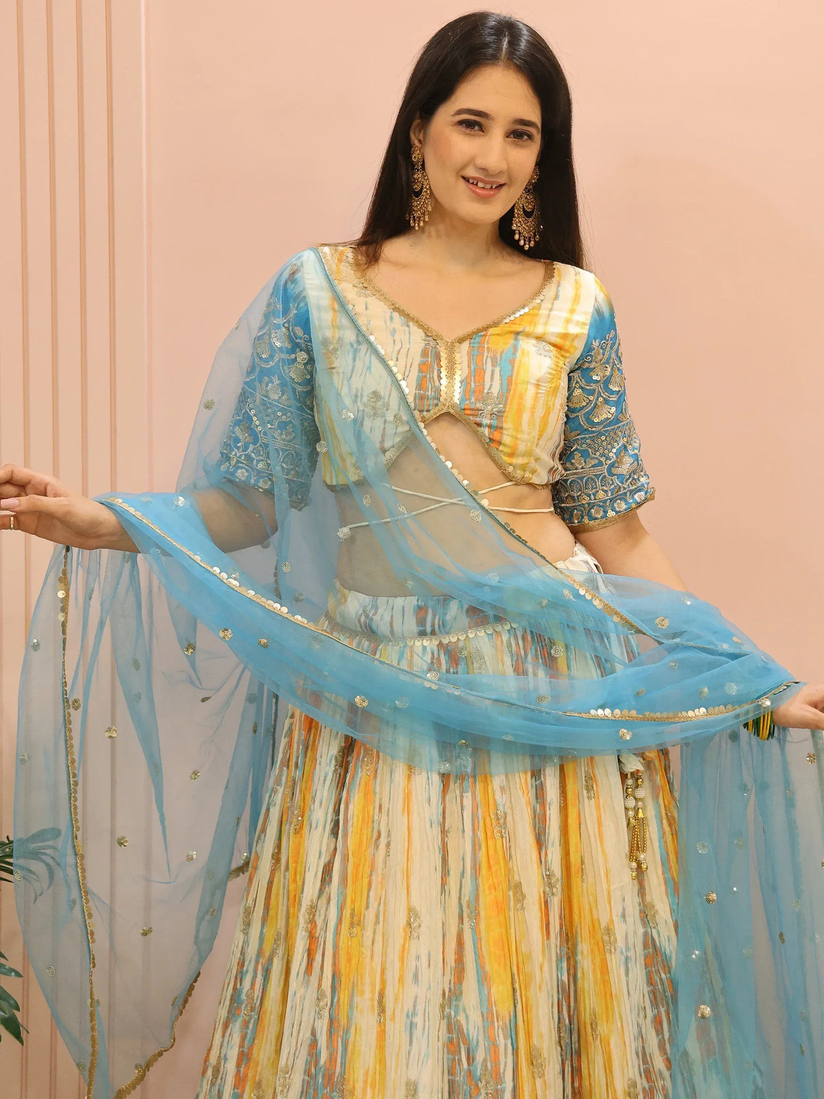 Woman in colorful designer lehenga choli with blue dupatta, perfect for Indian ethnic wear occasions
