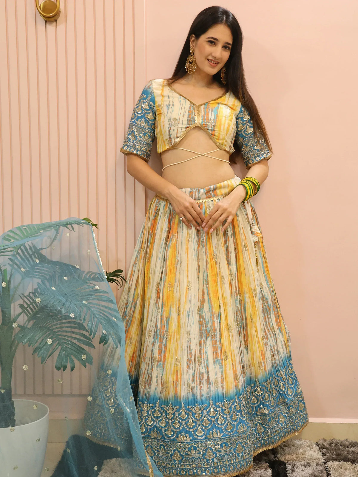 Woman in colorful printed lehenga choli with blue dupatta, ethnic Indian wear for festive occasions