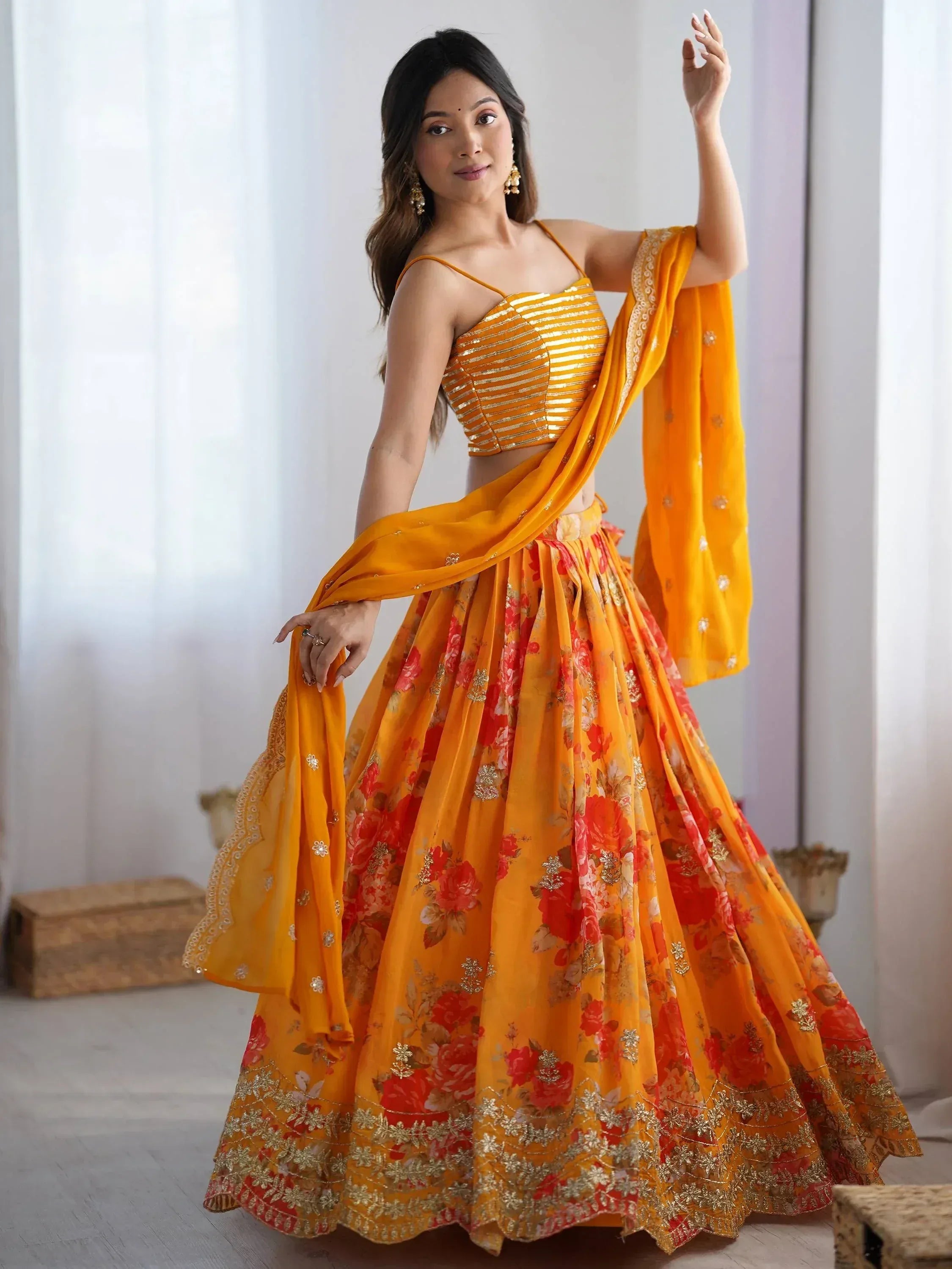 Vibrant orange floral lehenga choli with gold embroidery, perfect for Indian ethnic wear occasions.