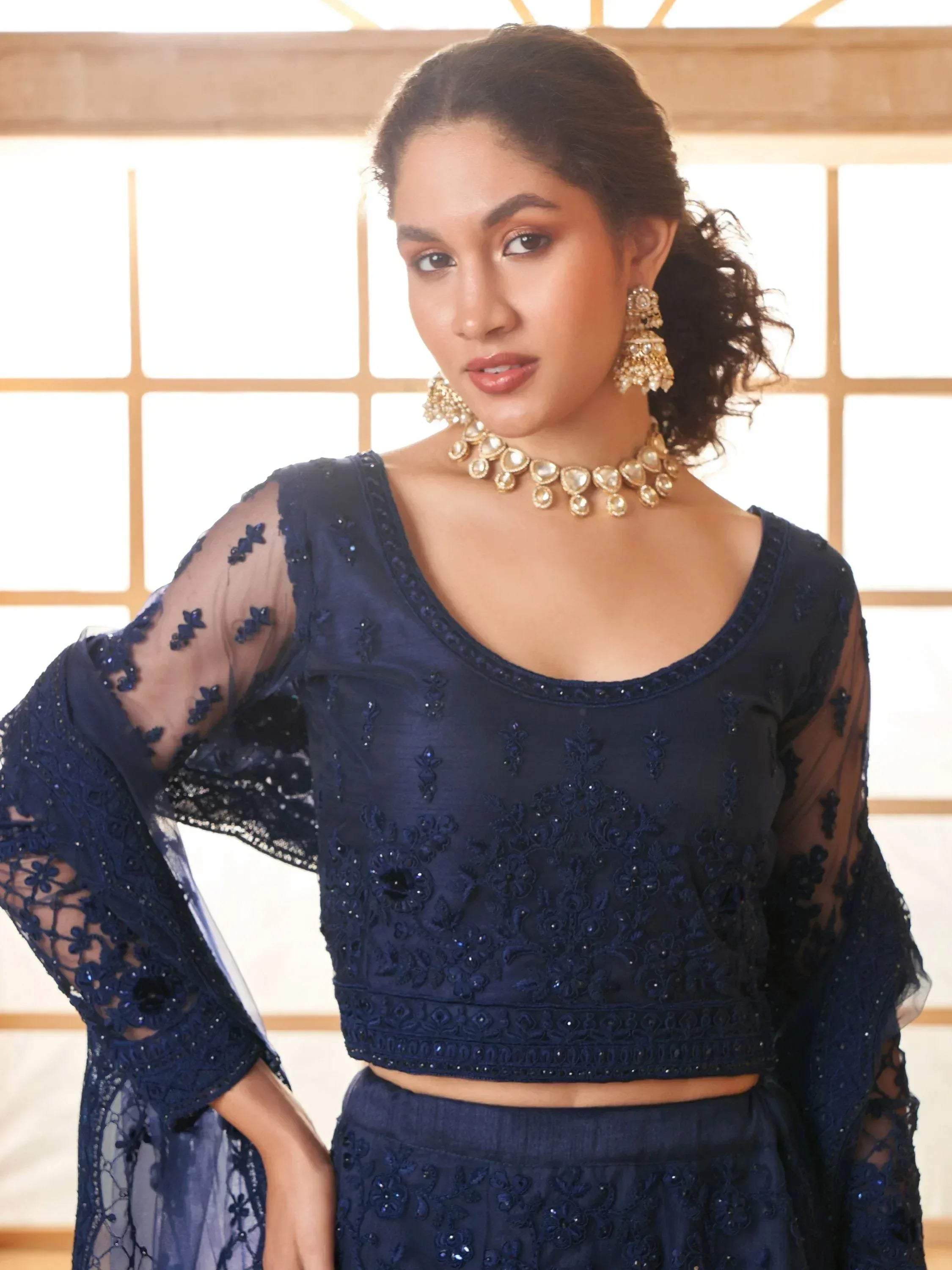 Navy blue embroidered ethnic crop top with sheer sleeves, paired with matching skirt and gold jewelry