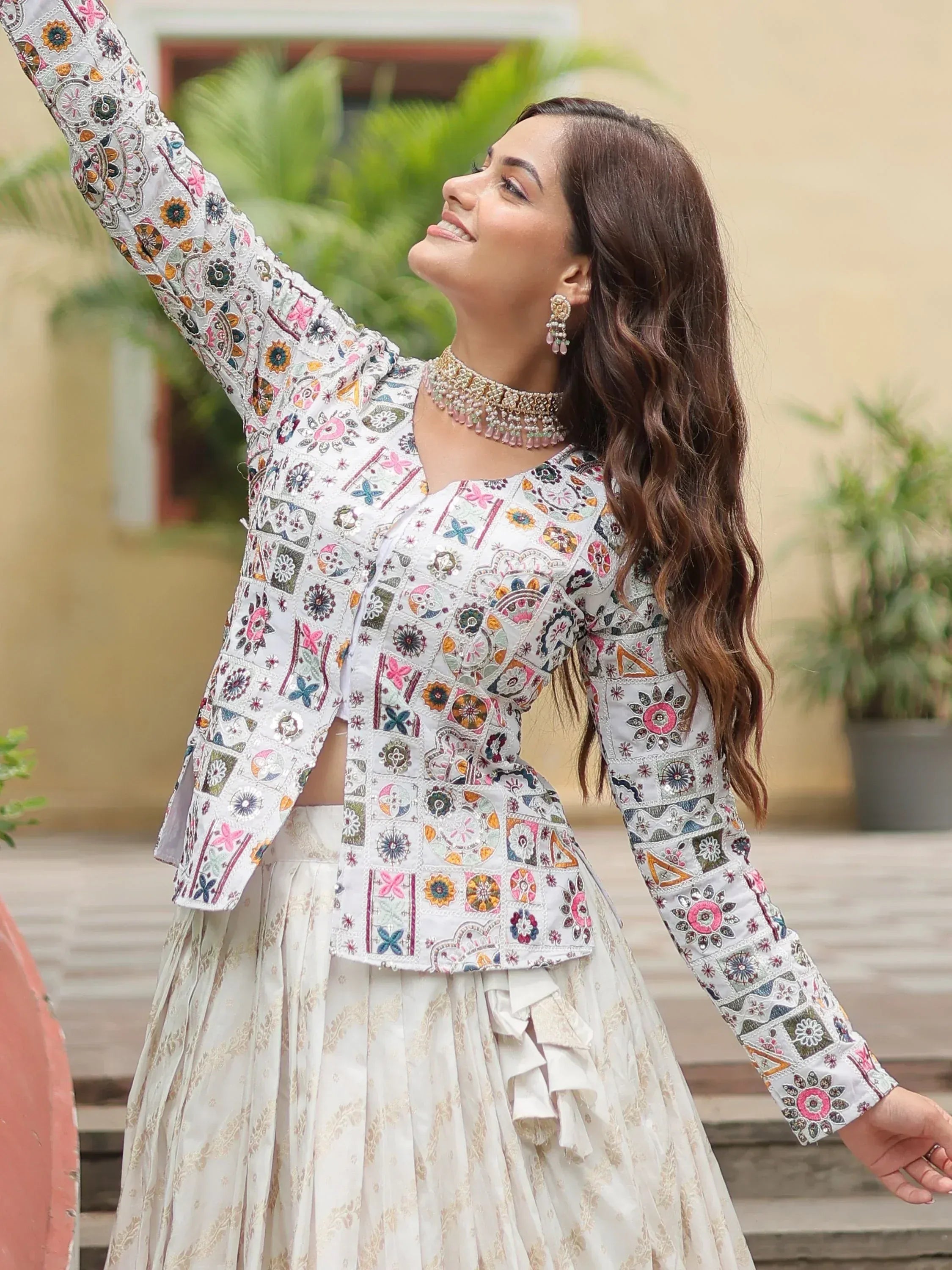 Woman in white embroidered ethnic lehenga choli with floral patchwork, perfect for Indian celebrations