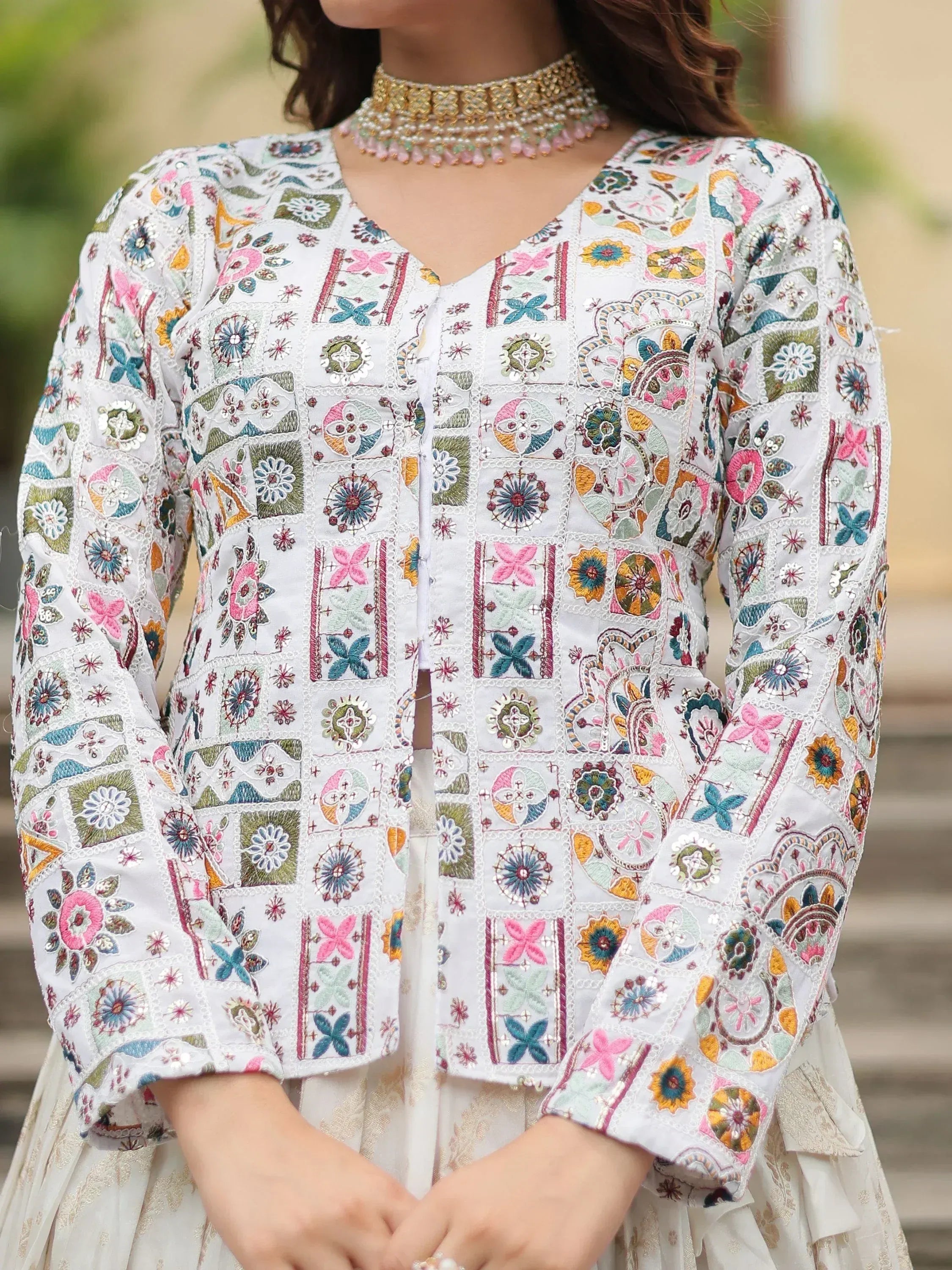 White embroidered ethnic jacket with floral patchwork, paired with choker necklace for traditional Indian wear
