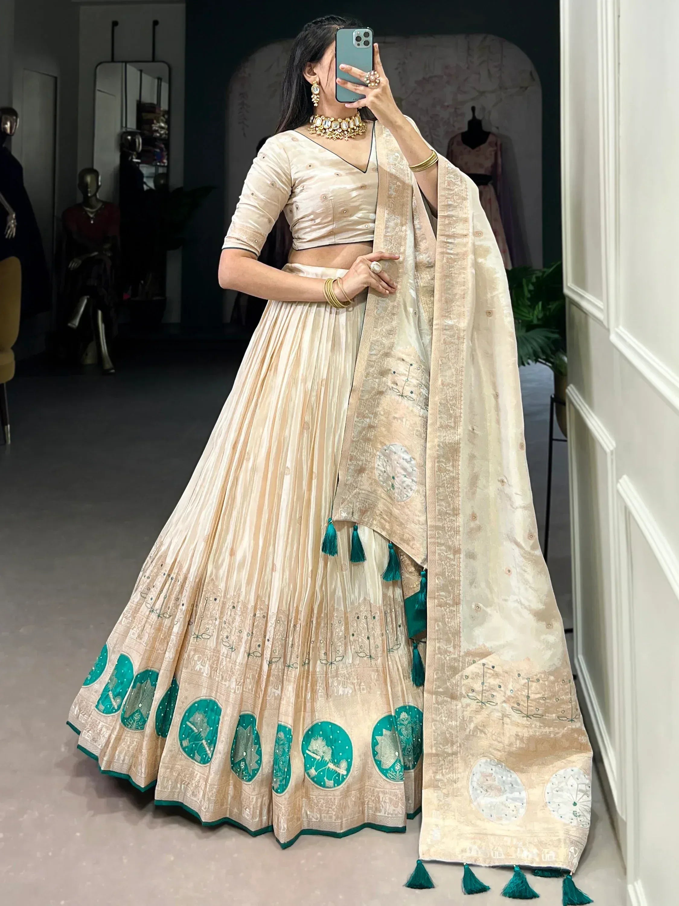 Cream and teal designer lehenga choli with embroidered motifs and tassels, perfect for Indian ethnic wear