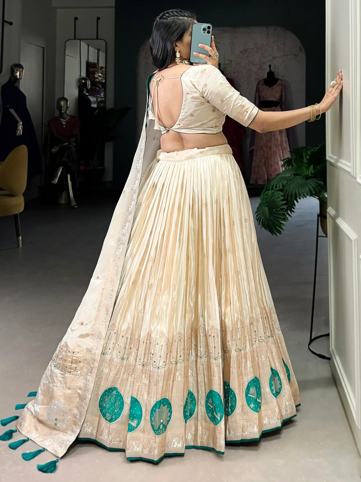 Cream and teal designer lehenga choli with backless blouse, pleated skirt, and embroidered dupatta for Indian ethnic wear