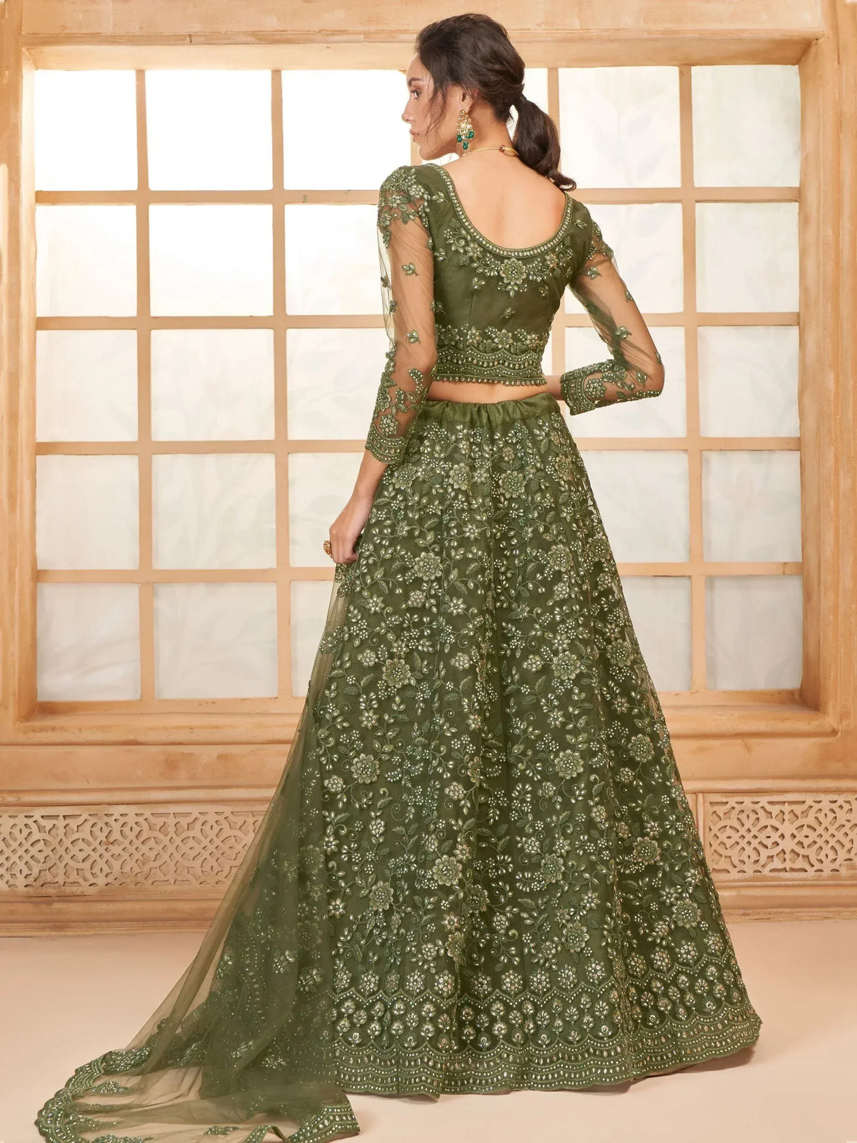 Olive green embroidered lehenga choli with sheer sleeves and floral detailing, perfect for Indian ethnic occasions.