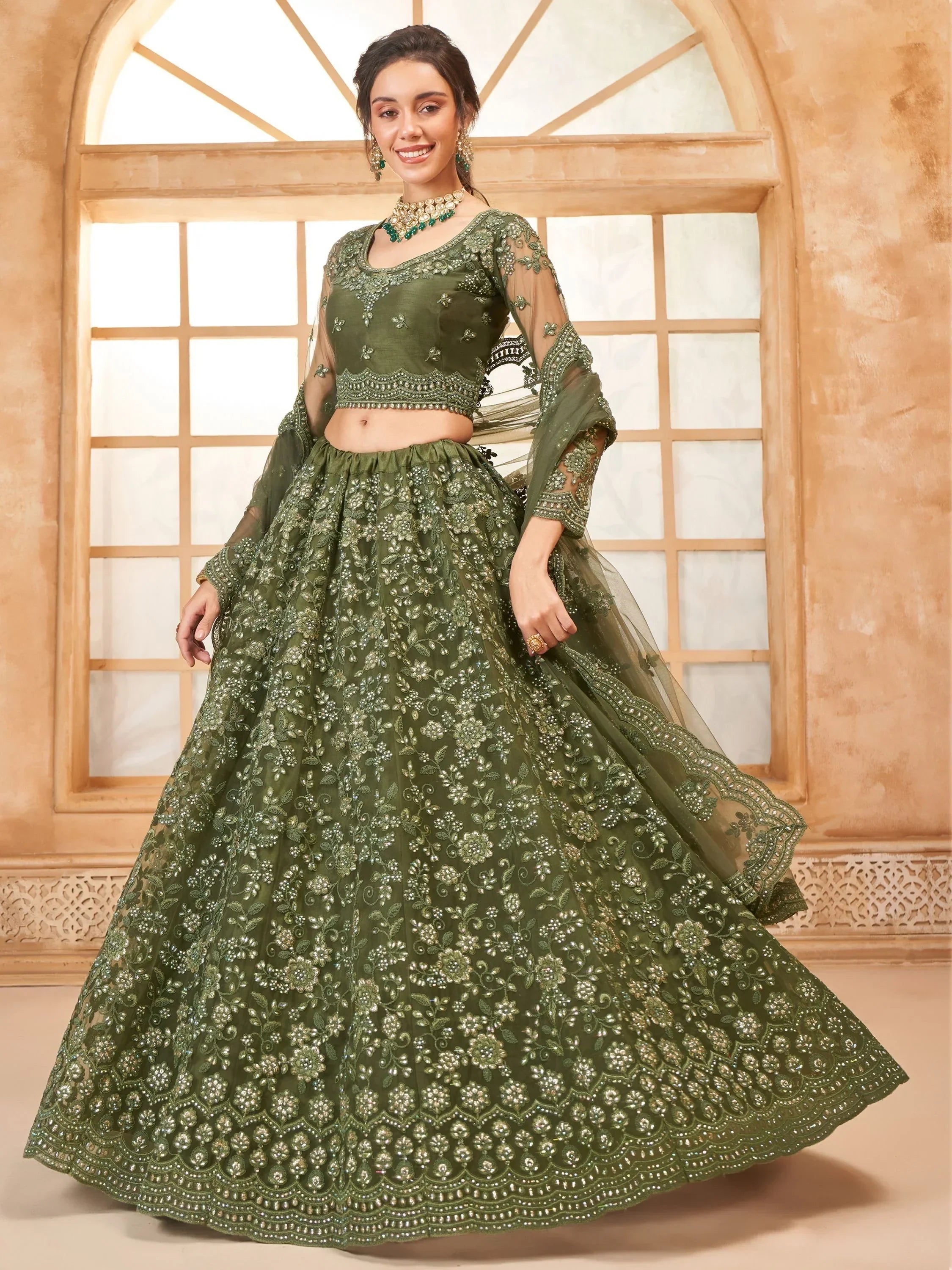 Olive green designer lehenga choli with heavy floral embroidery and sheer sleeves, perfect for weddings.