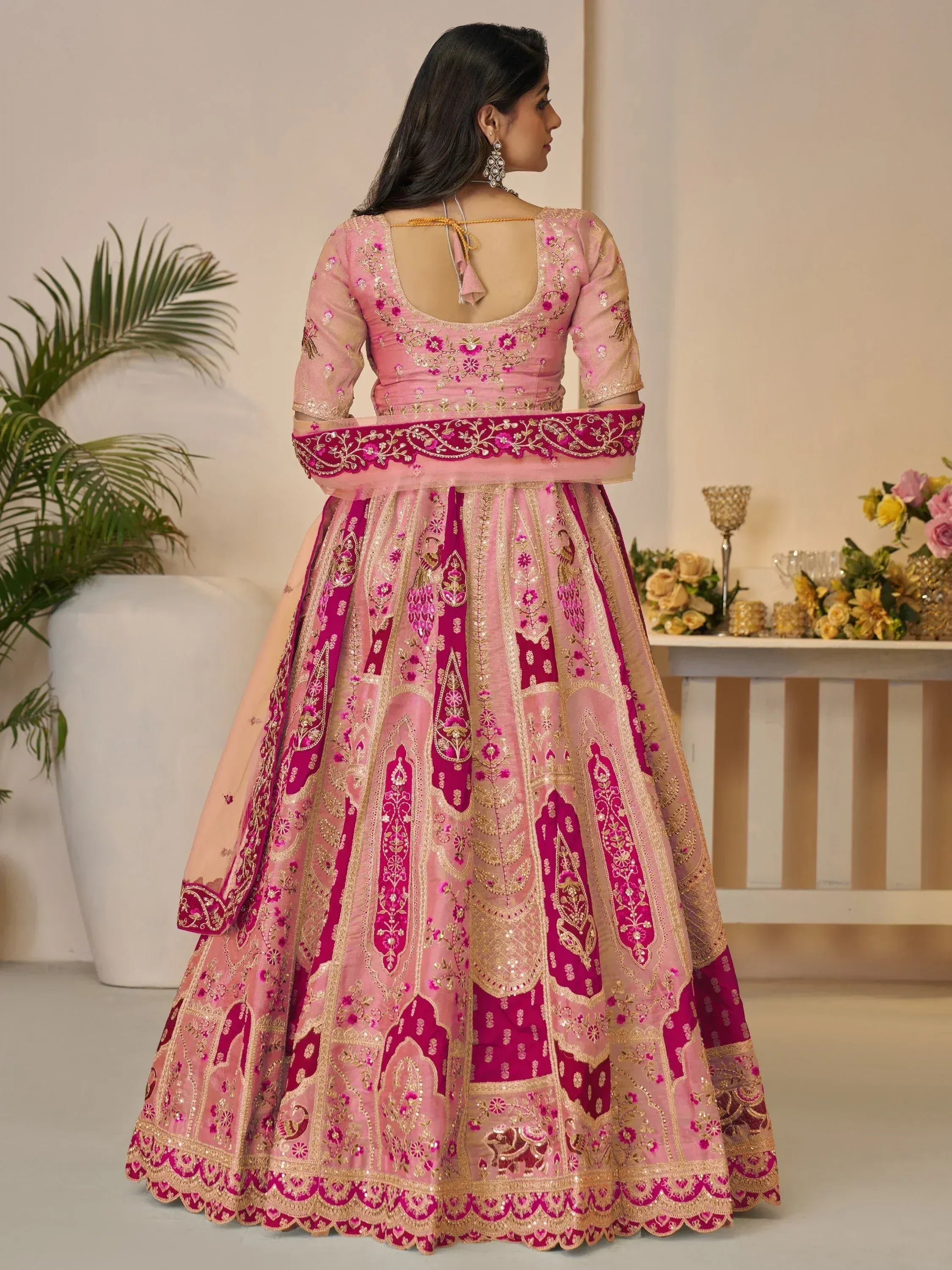 Pink and magenta embroidered lehenga choli with gold detailing, perfect for Indian weddings and festive occasions.
