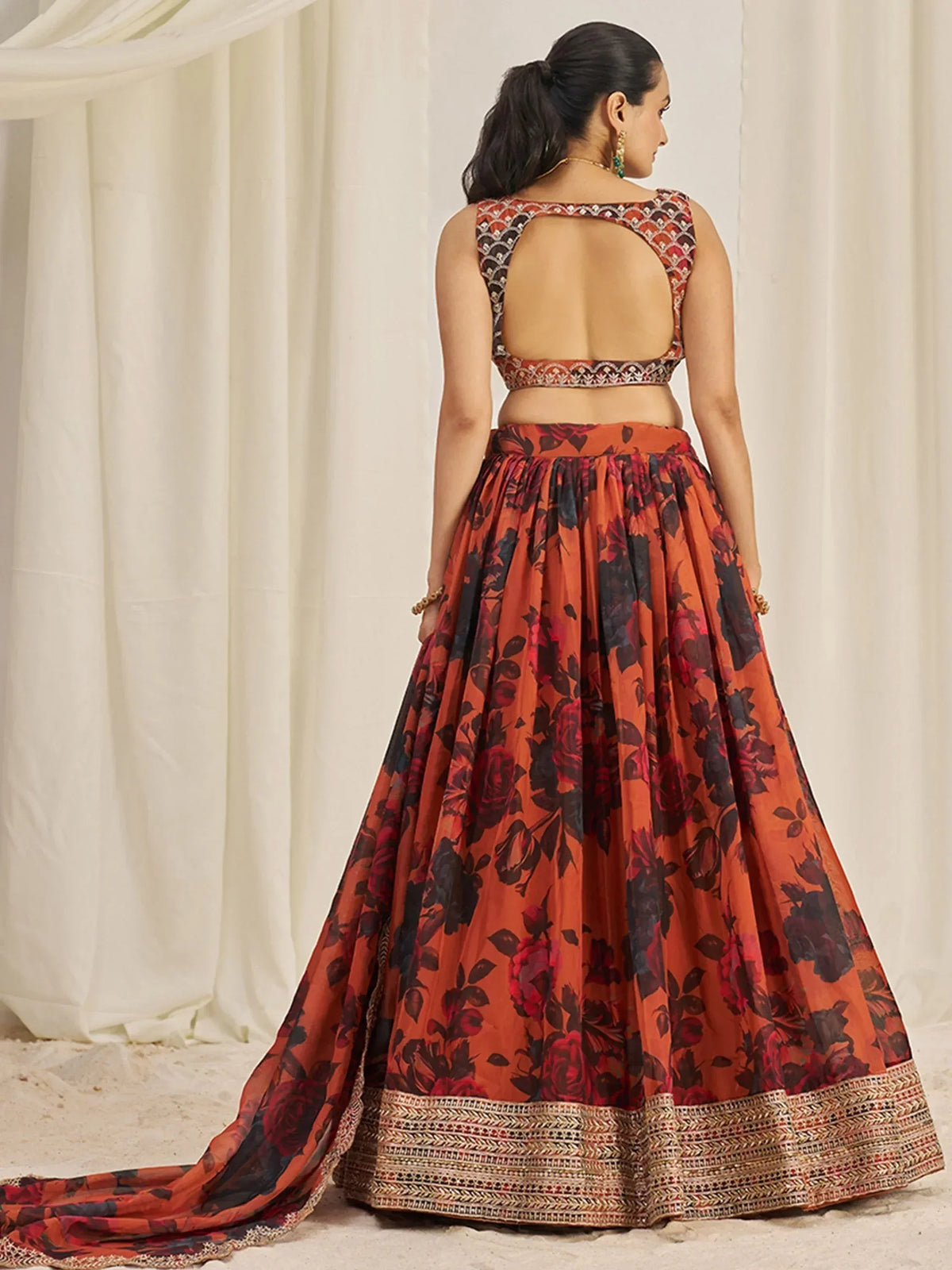 Orange floral lehenga choli with embroidered border and open back design
