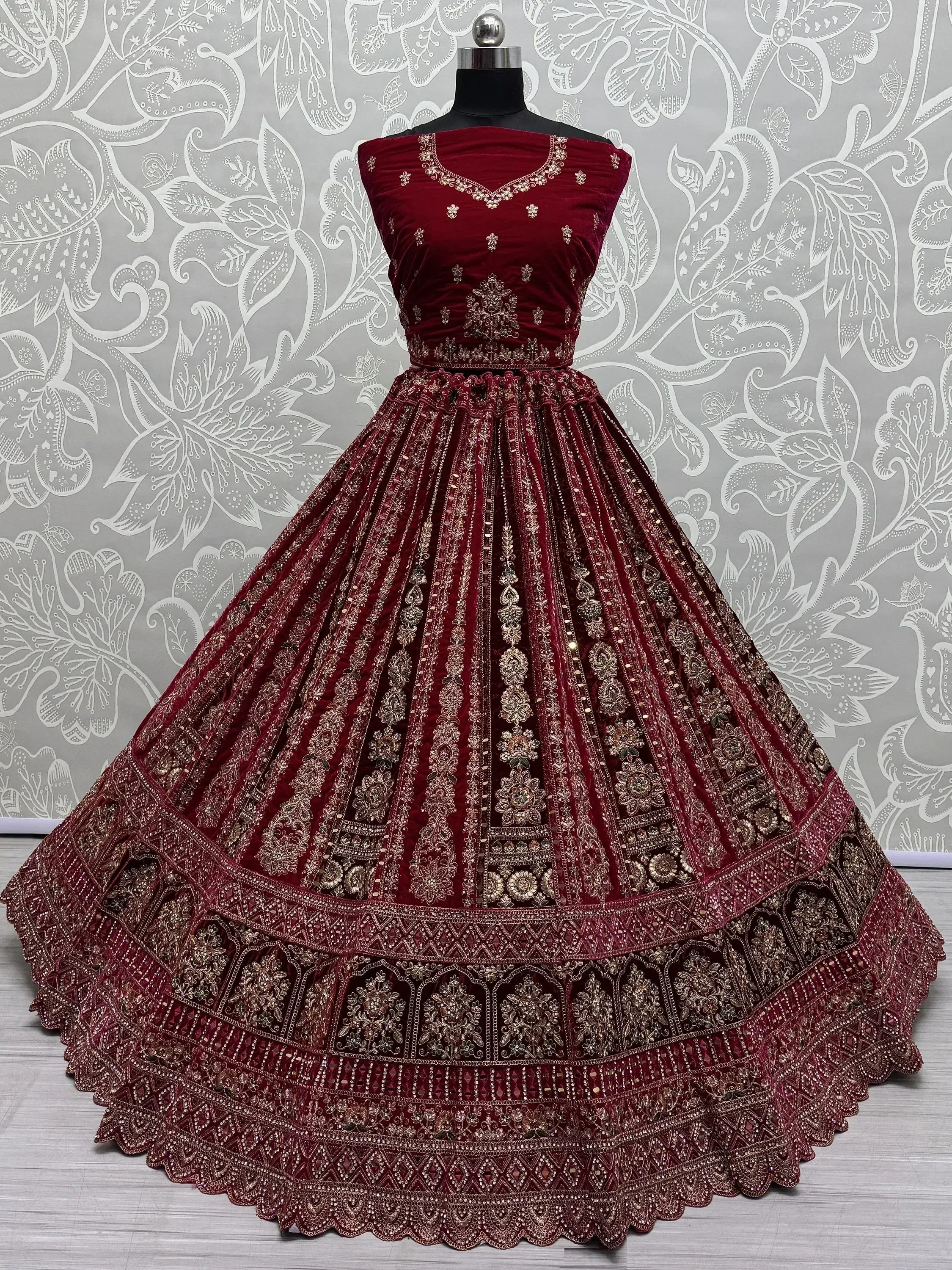 Maroon velvet lehenga choli with gold embroidery, perfect for Indian weddings and festive occasions.