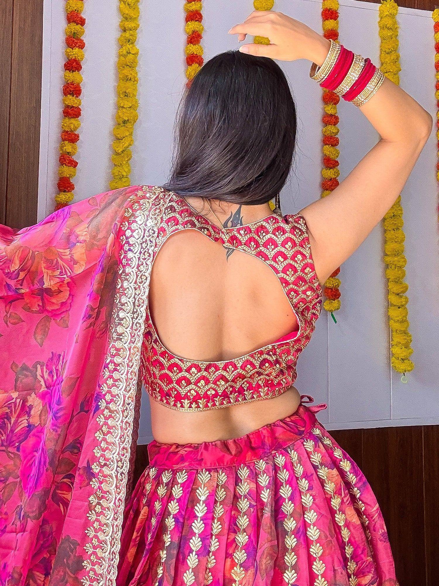 Pink floral lehenga choli with gold embroidery and open back design, paired with matching dupatta and bangles