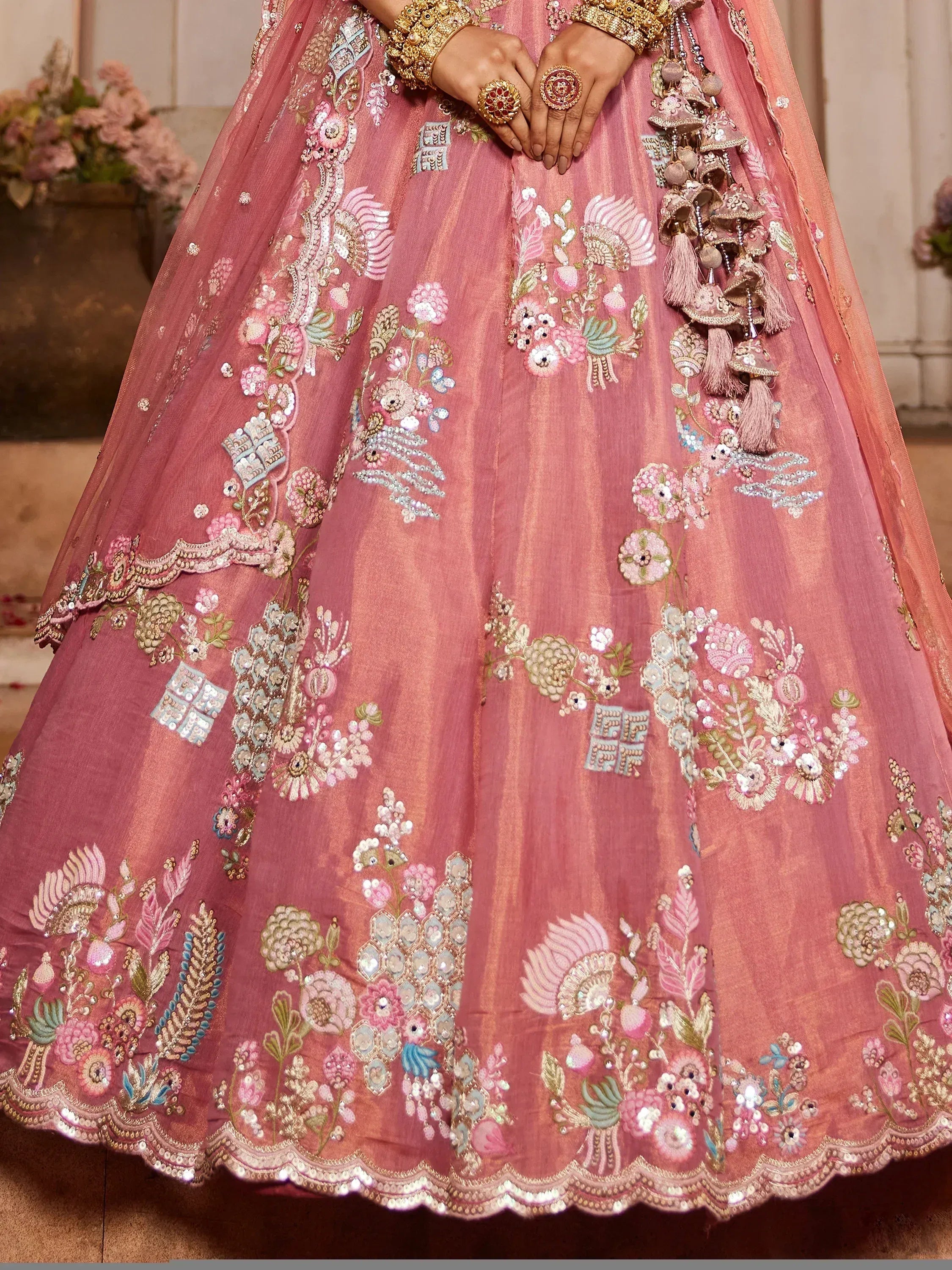 Pink designer lehenga with floral embroidery, sequins, and gold jewelry for Indian ethnic wear