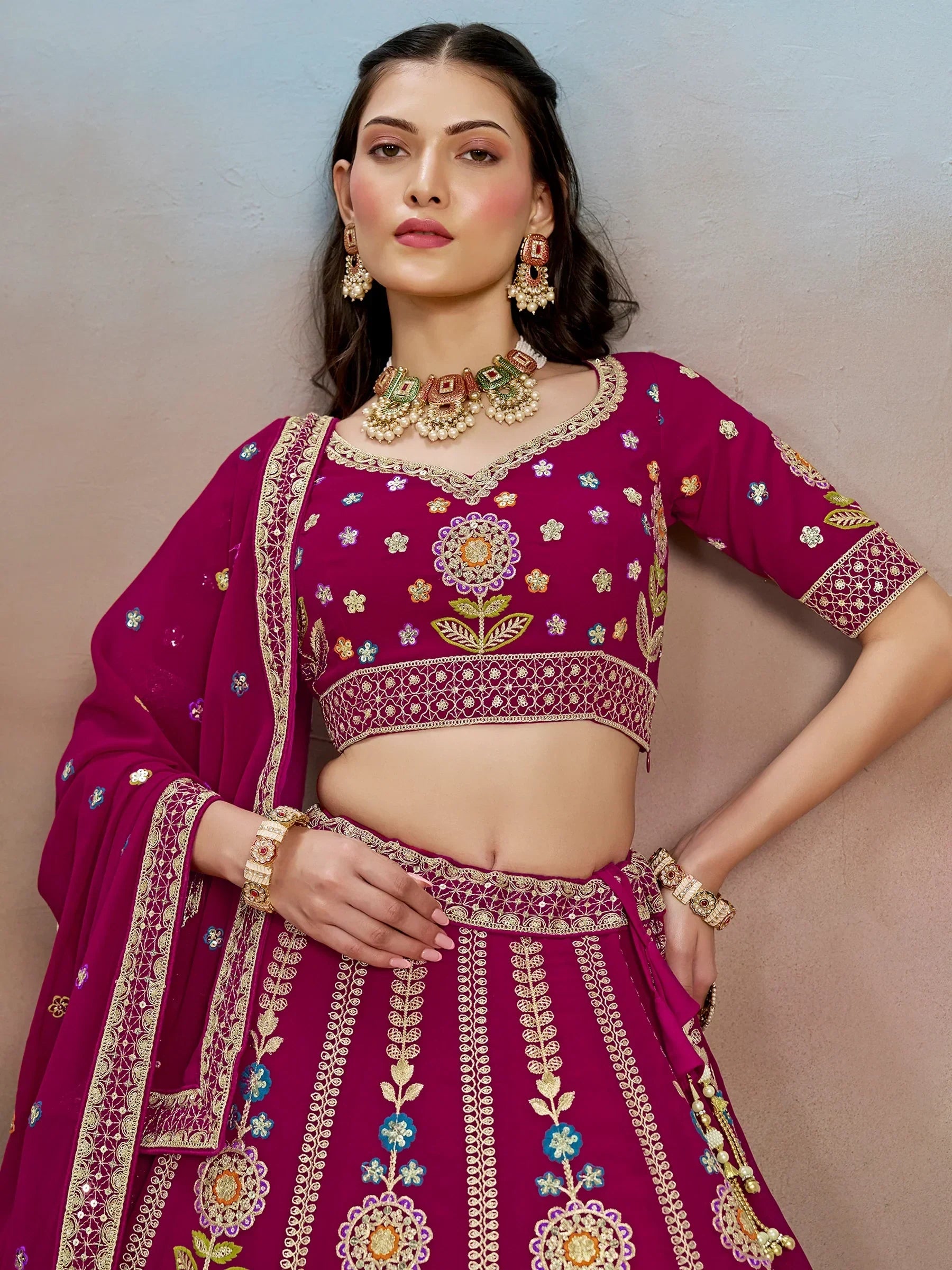 Magenta embroidered lehenga choli with floral motifs and gold detailing, perfect for Indian ethnic wear