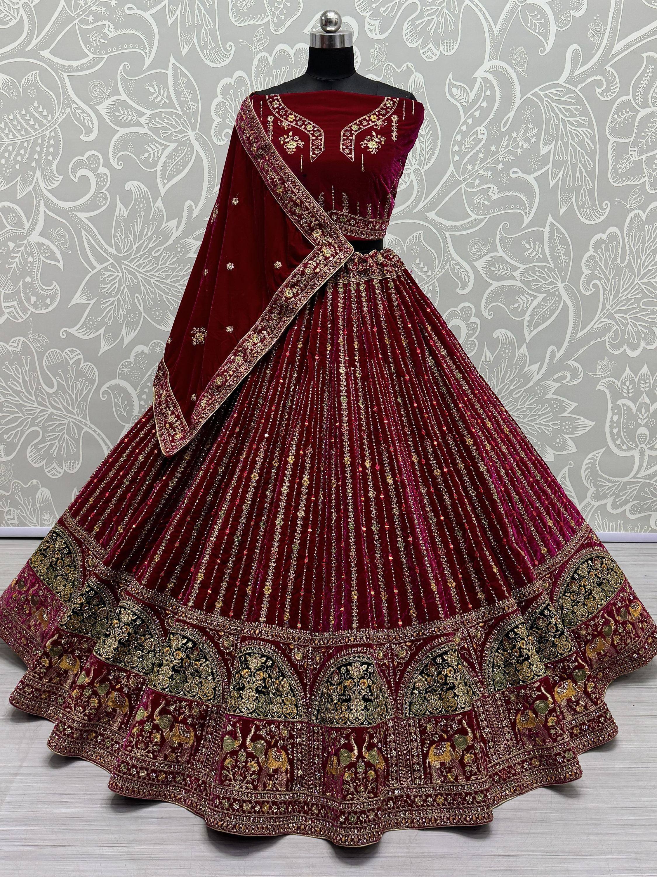 Maroon velvet designer lehenga choli with gold embroidery and elephant motifs, perfect for Indian weddings.