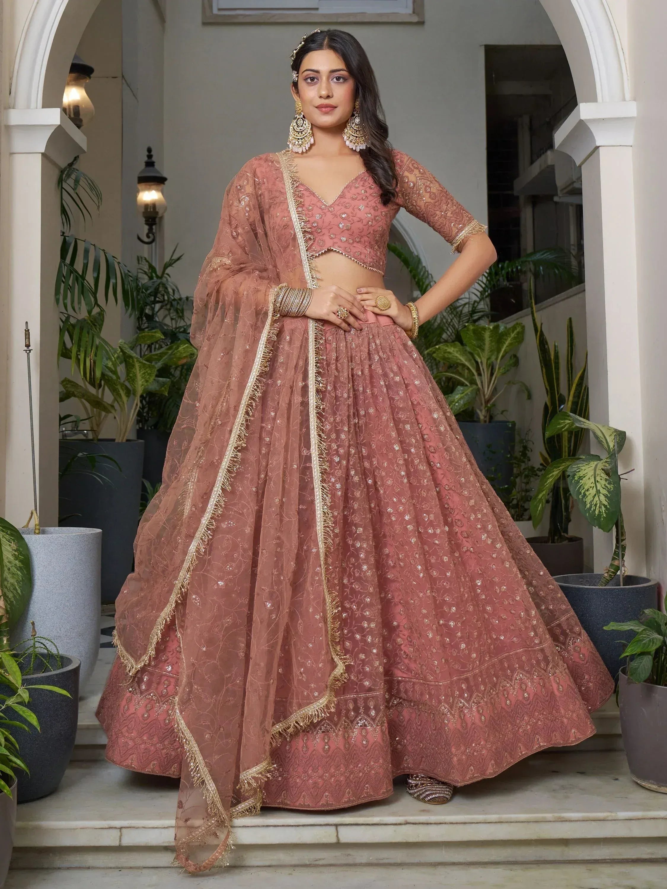 Dusty pink embroidered lehenga choli with gold detailing, perfect for Indian weddings and festive occasions.