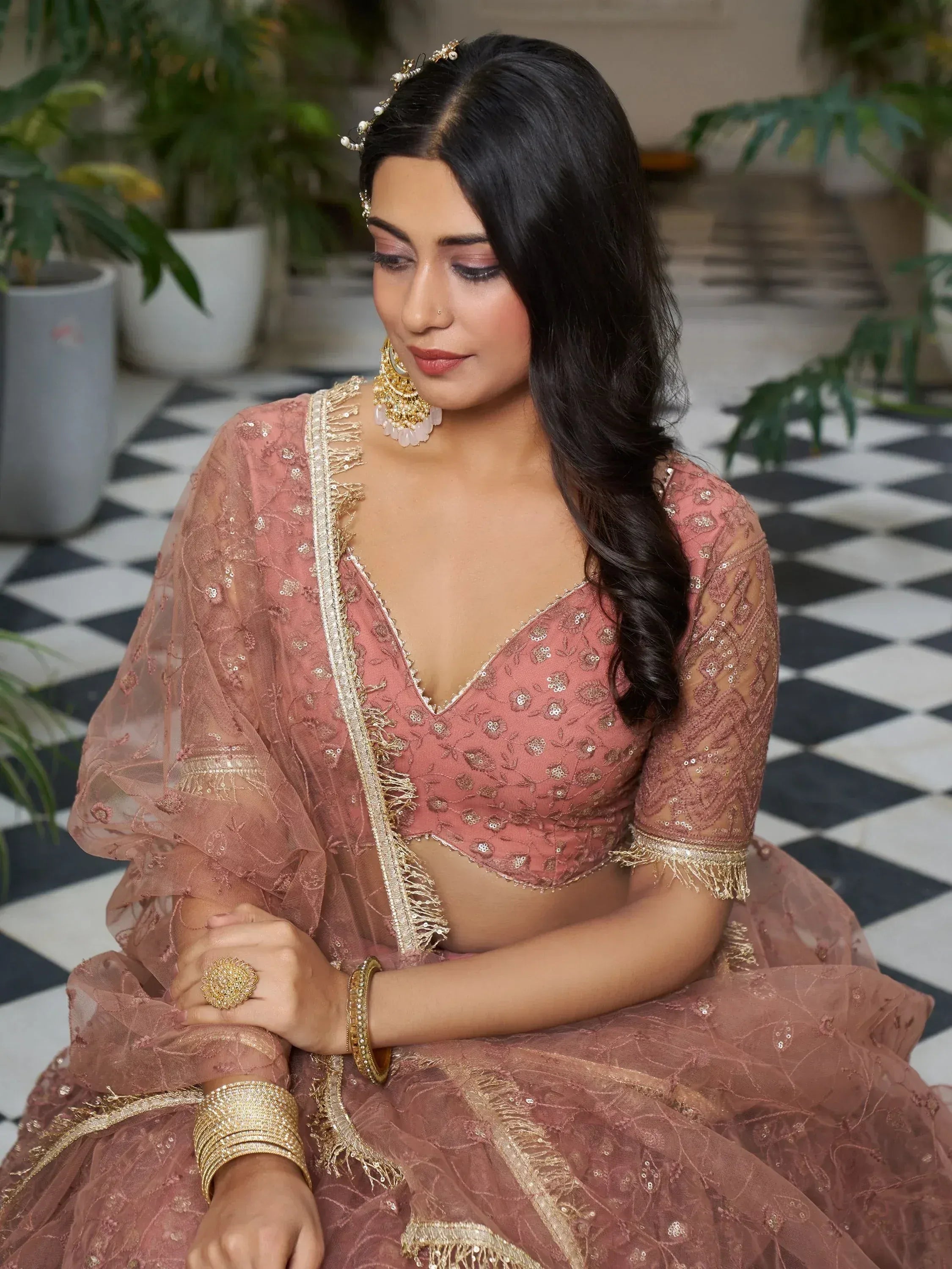 Elegant dusty rose lehenga choli with gold embroidery, perfect for Indian weddings and festive occasions.