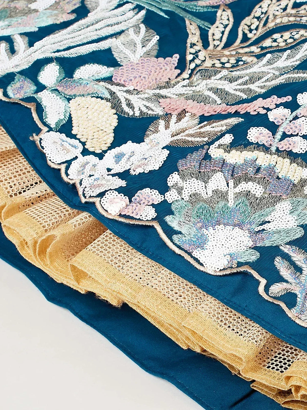 Teal ethnic gown with floral embroidery and gold lace trim, perfect for Indian occasions