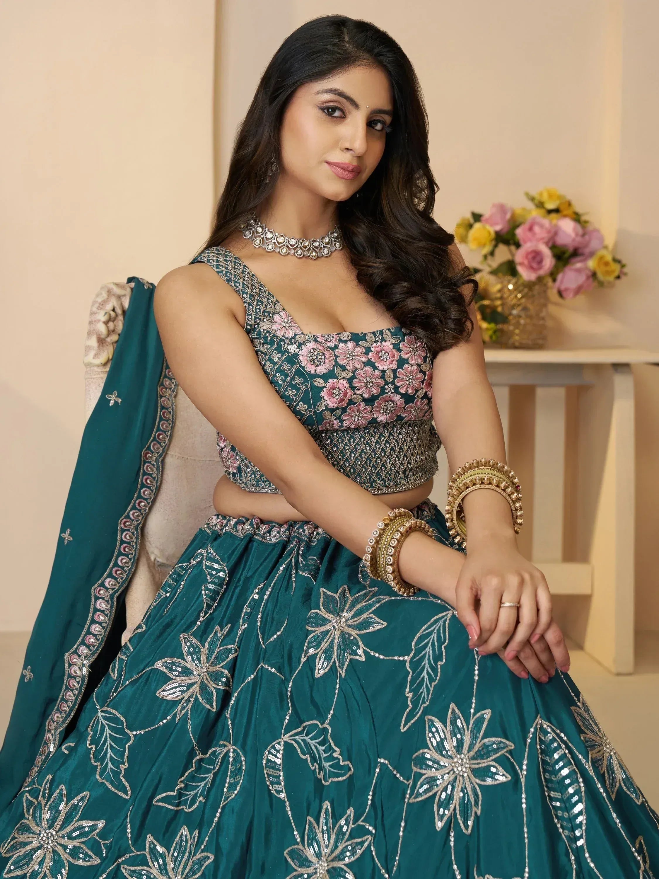 Teal floral embroidered lehenga choli with pink and gold detailing, perfect for Indian ethnic occasions.