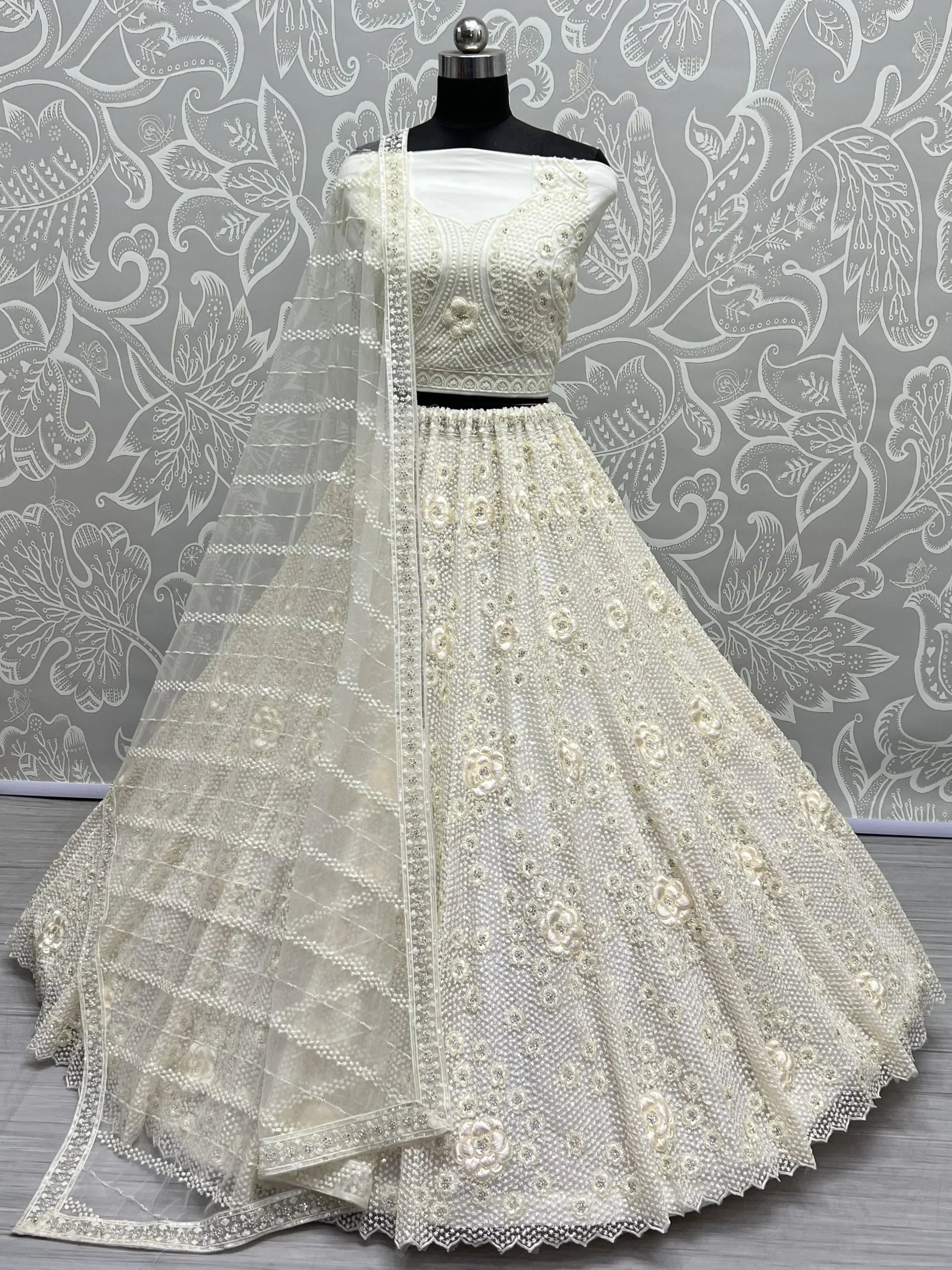 Elegant white embroidered lehenga choli with floral motifs and sheer dupatta, perfect for Indian ethnic wear