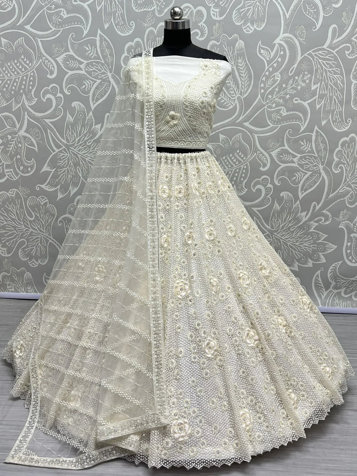 Elegant white embroidered lehenga choli with floral motifs and sheer dupatta, perfect for Indian ethnic wear