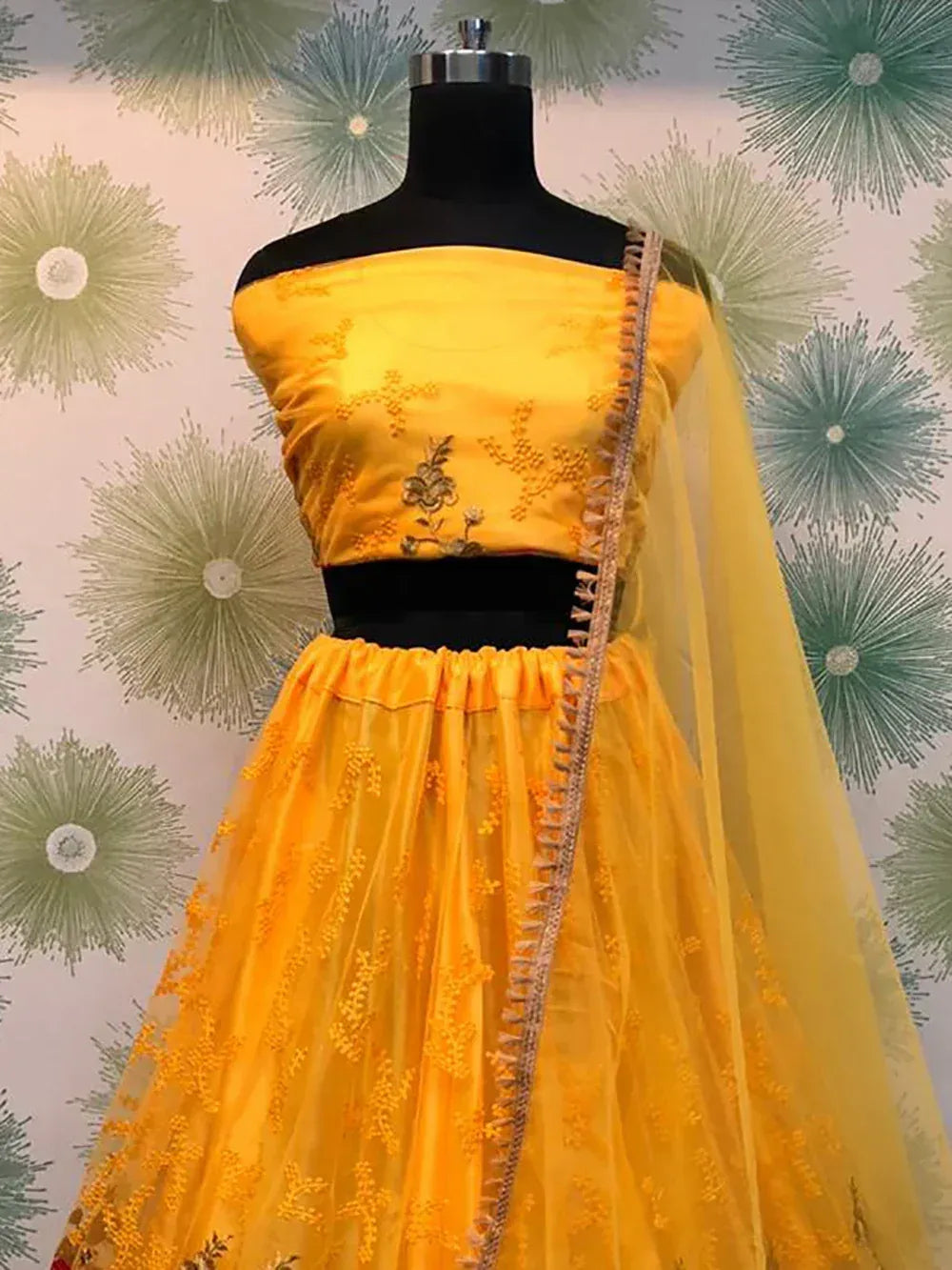Yellow embroidered lehenga choli with floral detailing and sheer dupatta for ethnic wear