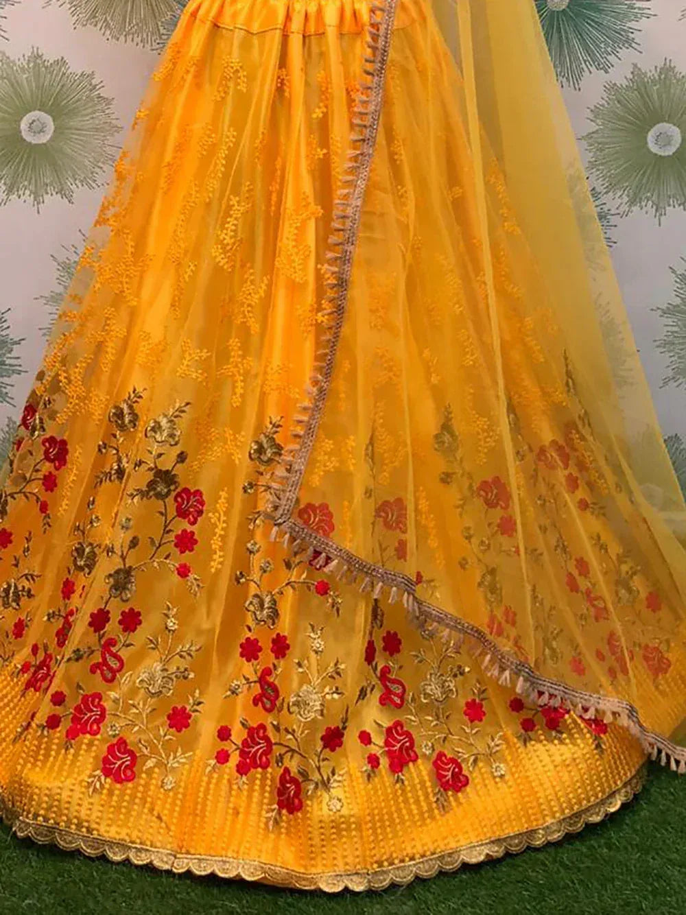 Yellow embroidered lehenga with red floral designs and golden detailing