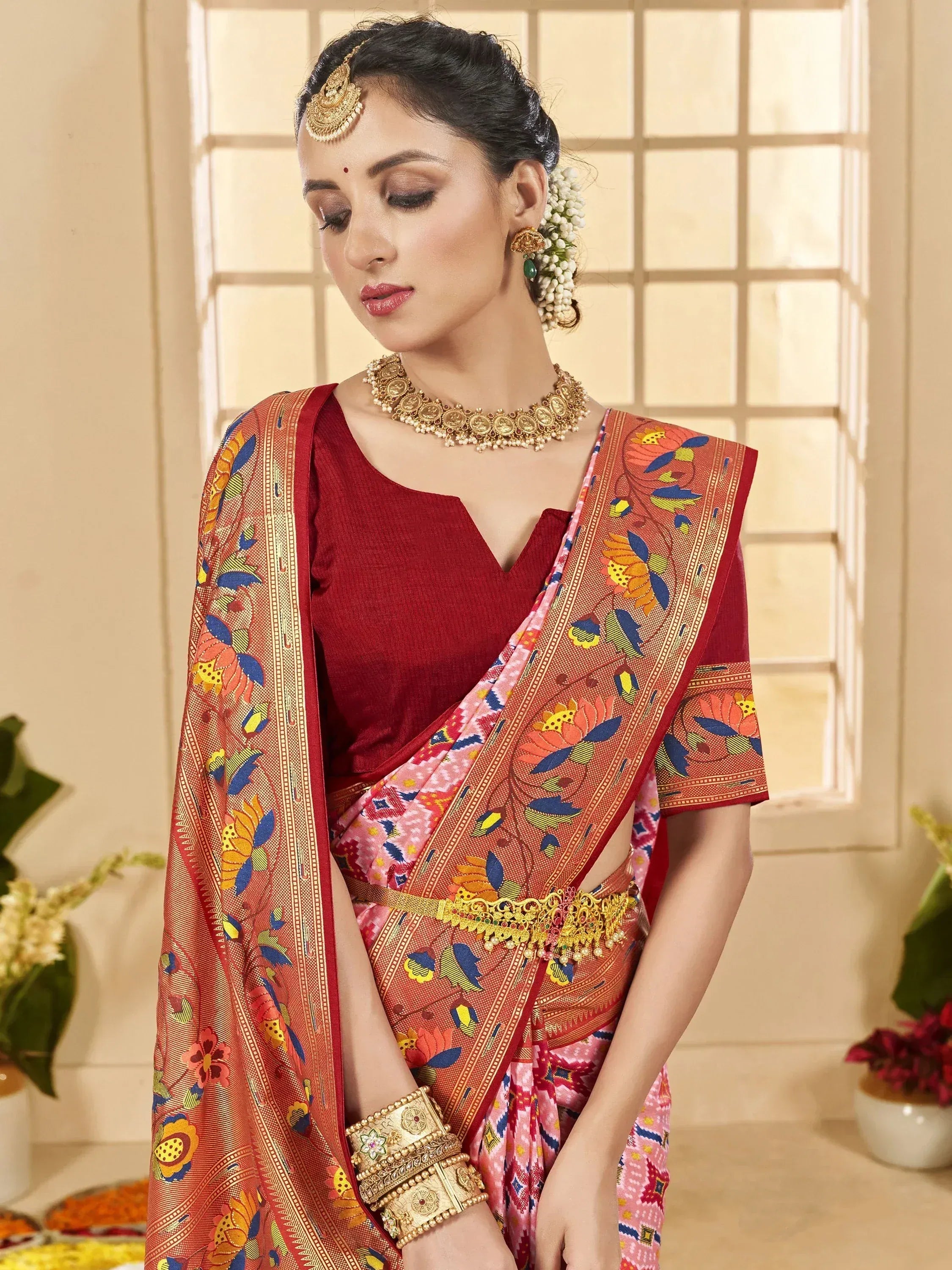 Woman in vibrant floral saree with gold jewelry, traditional Indian ethnic wear for festive occasions