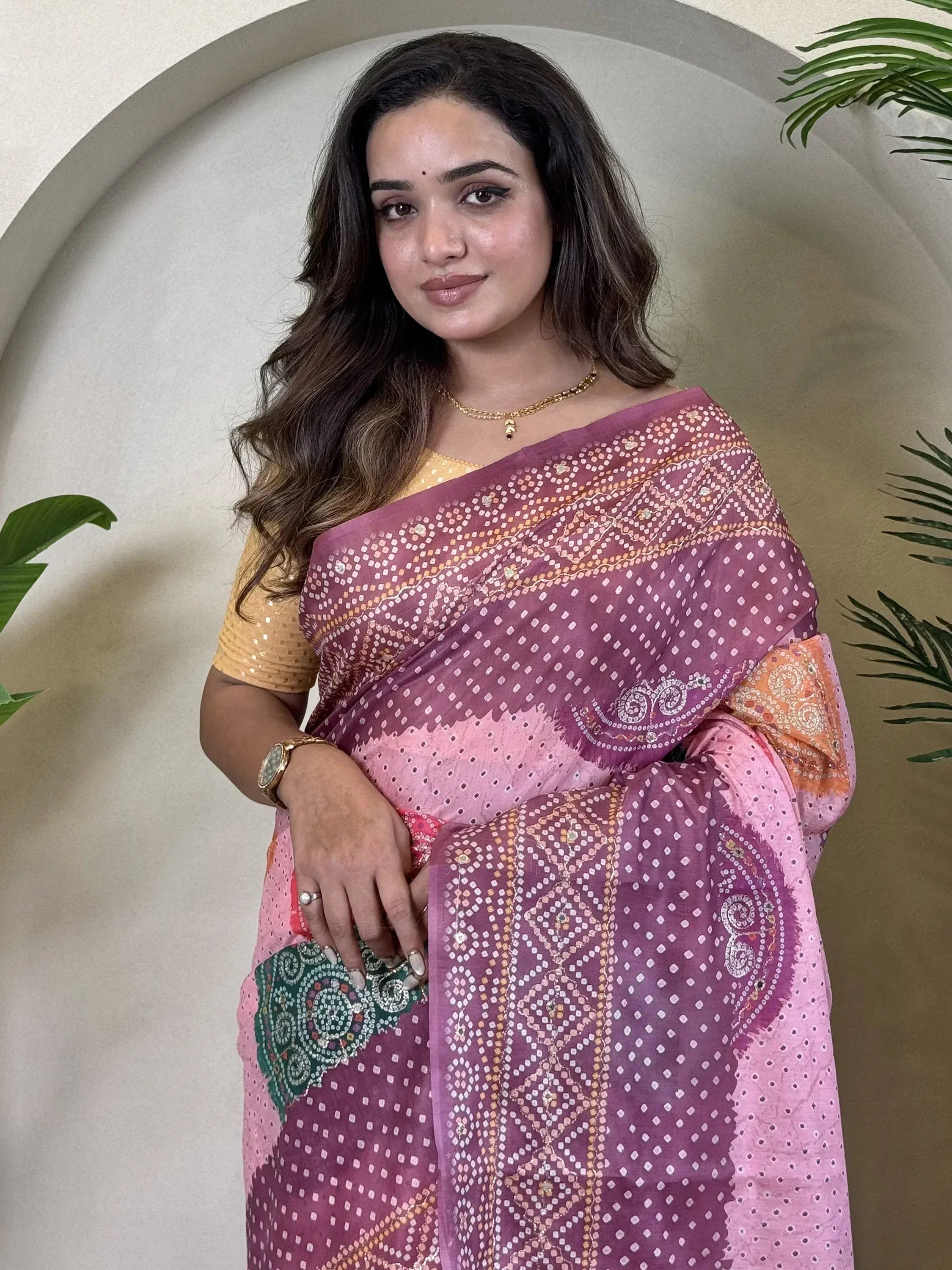 Woman in pink and purple printed saree with gold blouse, ethnic Indian wear