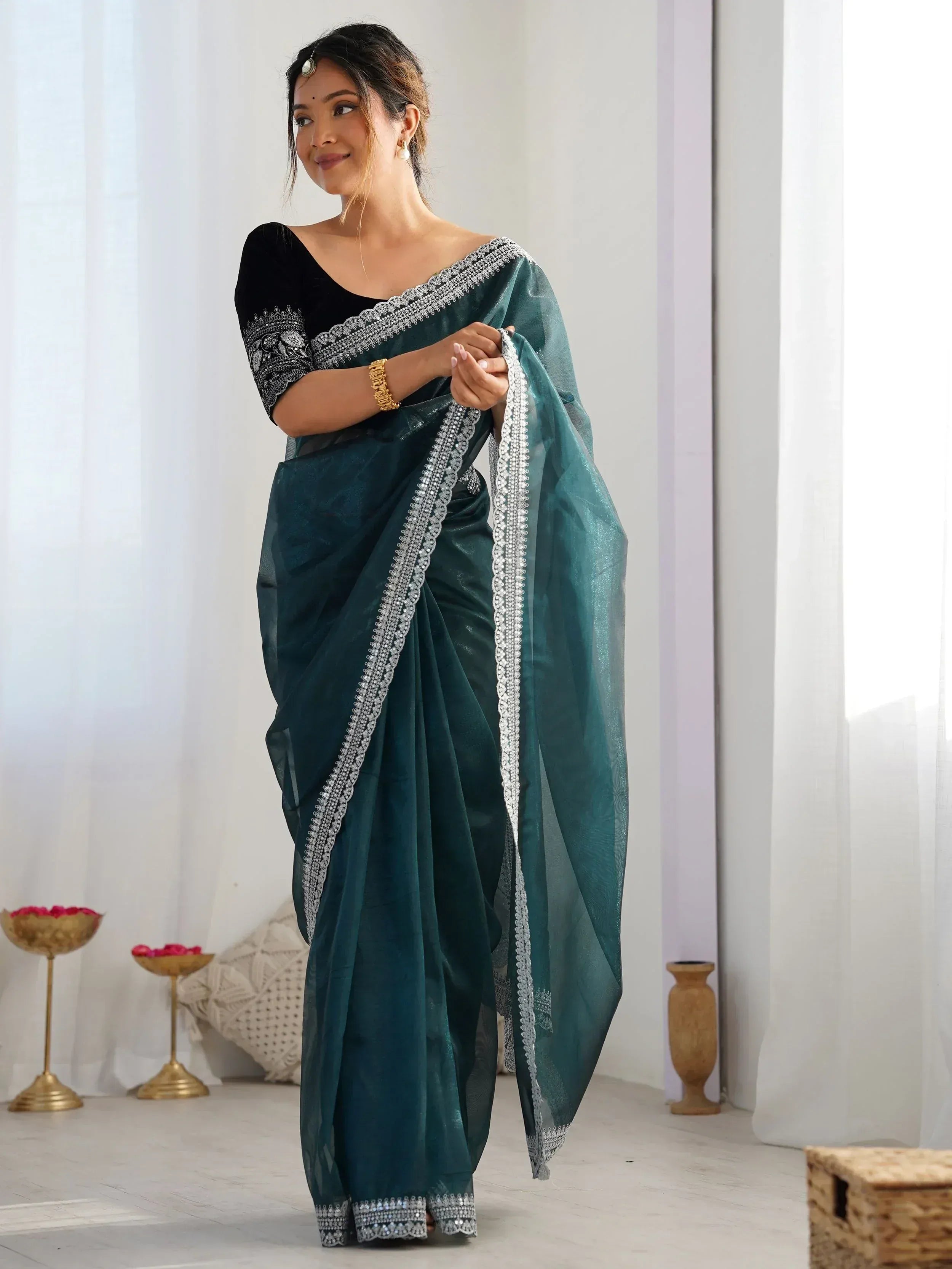 Elegant teal saree with silver embroidery, paired with black blouse, perfect for Indian ethnic occasions.