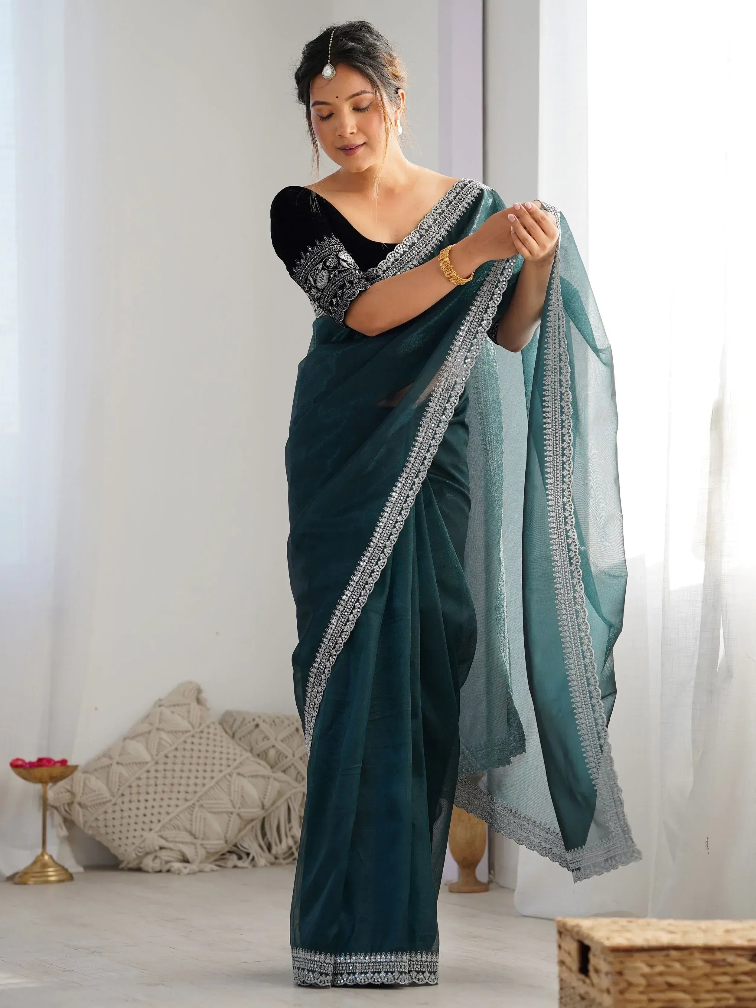 Elegant teal saree with silver embroidery, paired with black velvet blouse, perfect for Indian ethnic occasions.