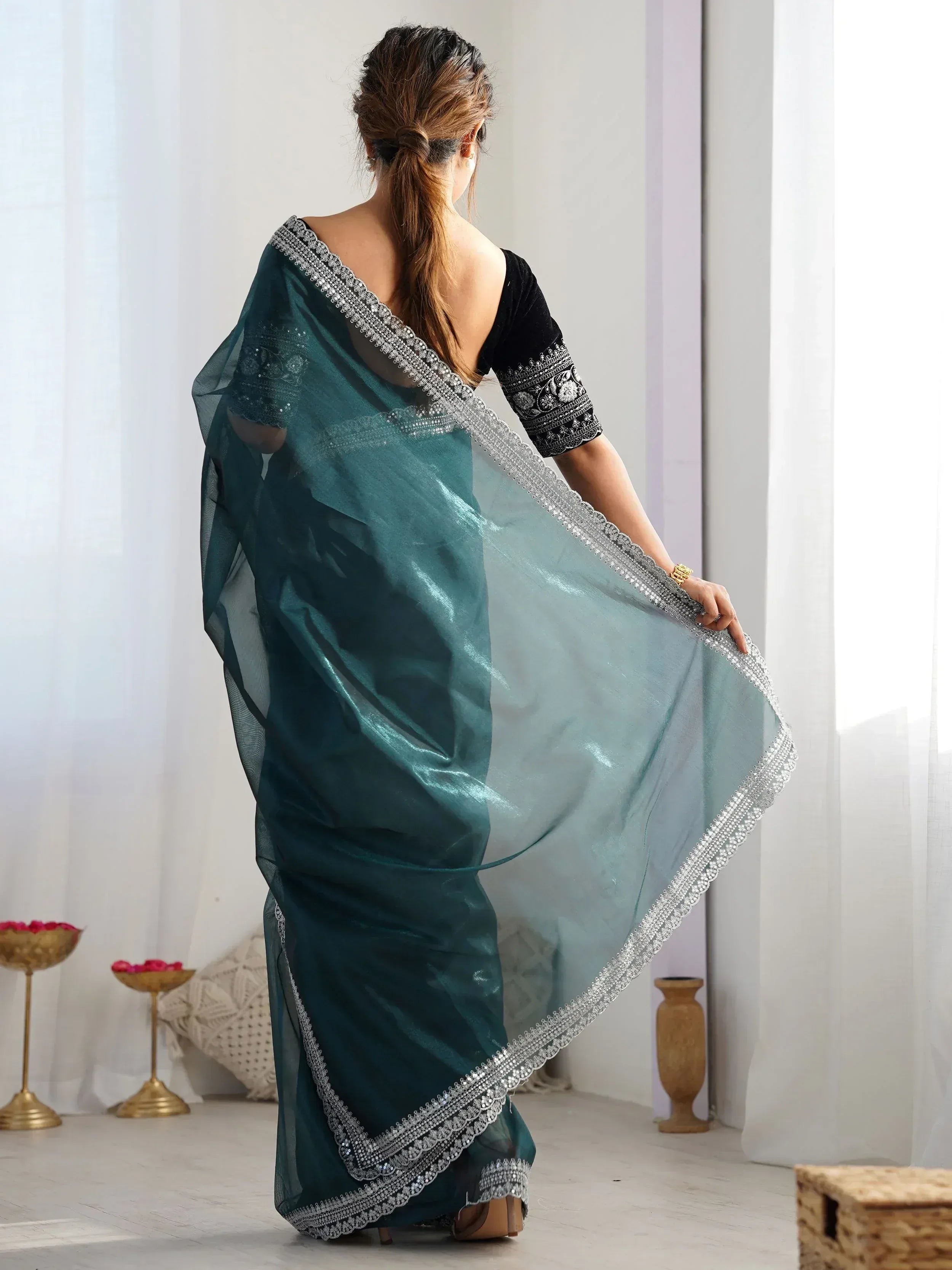 Teal designer saree with silver embellished border and black embroidered blouse, perfect for Indian ethnic wear.