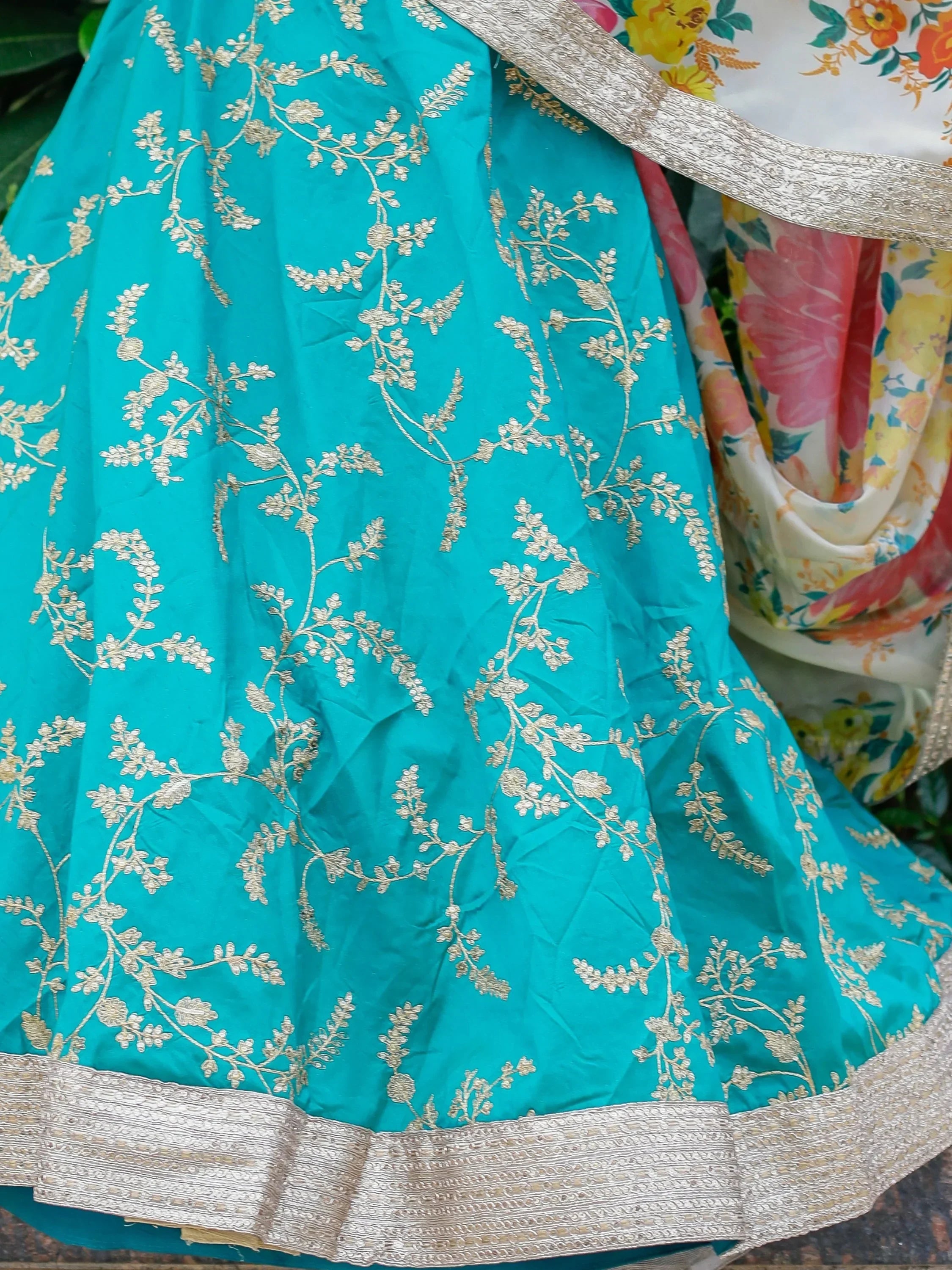 Turquoise lehenga with gold floral embroidery and silver border, paired with floral dupatta
