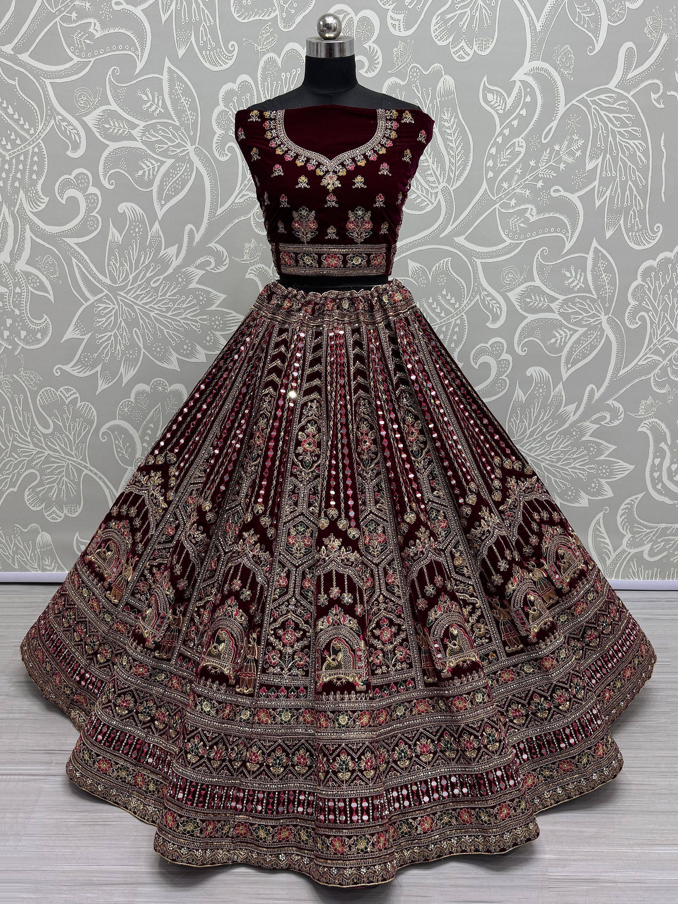 Maroon velvet designer lehenga choli with heavy gold embroidery and mirror work, perfect for weddings